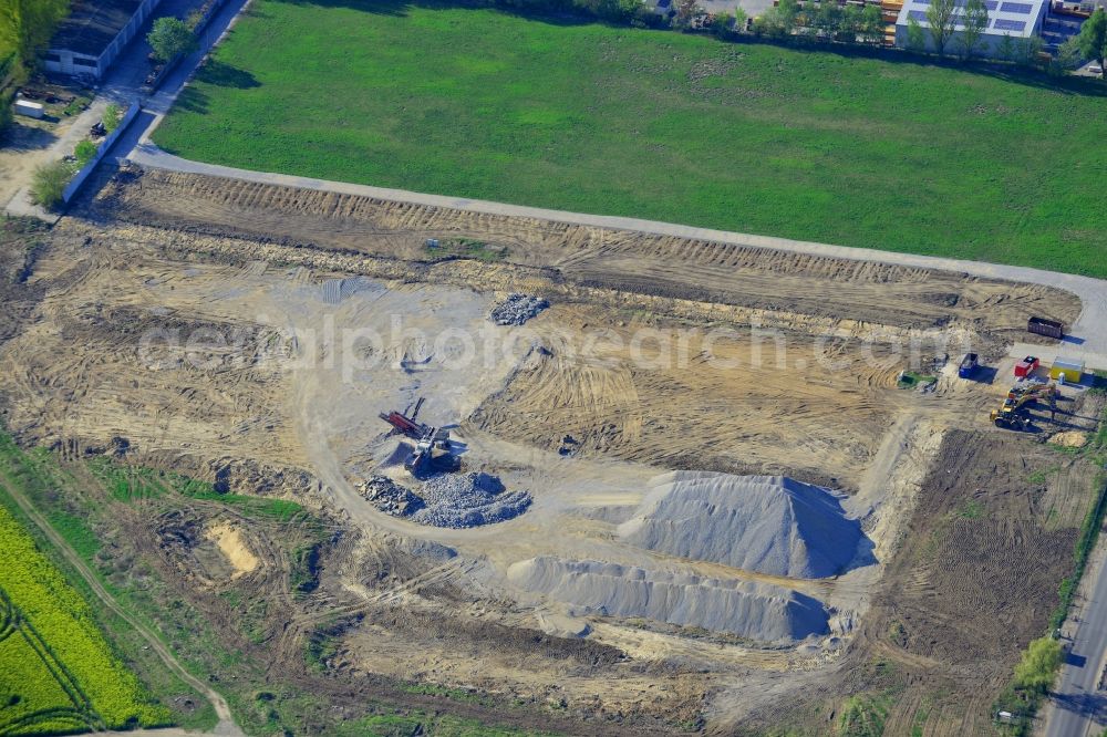 Aerial photograph Berlin - Construction site on Pilgramer Strasse in the Mahlsdorf part of the district of Marzahn-Hellersdorf in Berlin in Germany. The site is located opposite single family homes and is surrounded by fields and meadows. It is supposed to become a furniture store