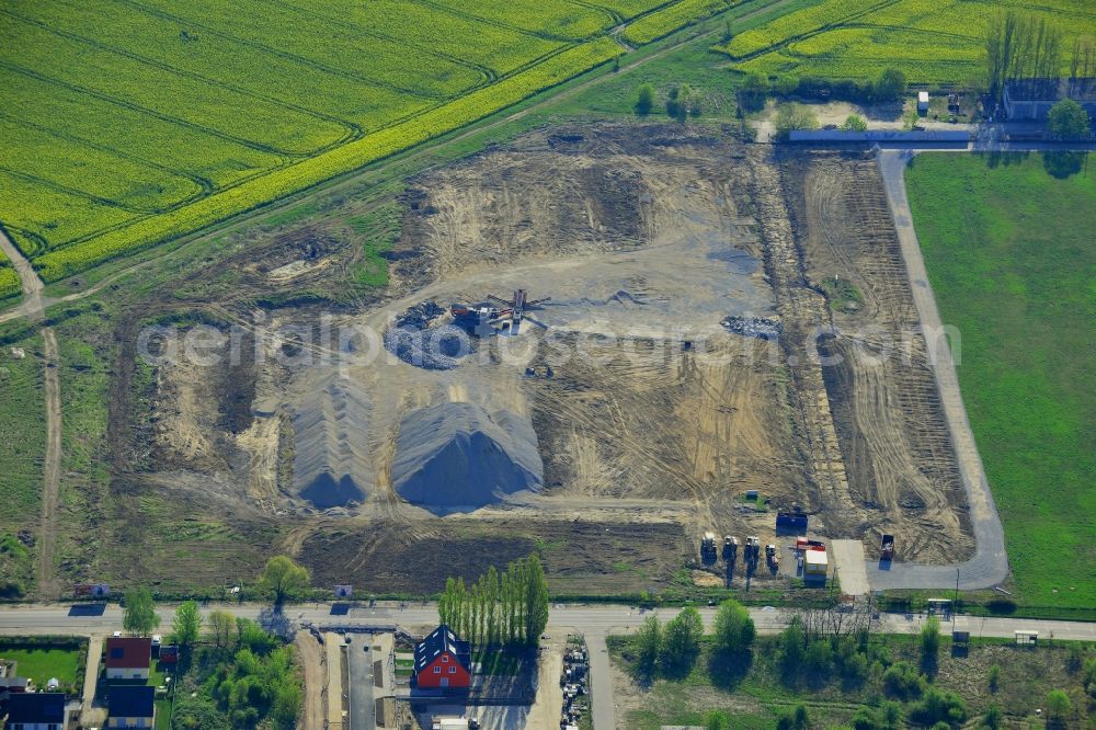 Berlin from above - Construction site on Pilgramer Strasse in the Mahlsdorf part of the district of Marzahn-Hellersdorf in Berlin in Germany. The site is located opposite single family homes and is surrounded by fields and meadows. It is supposed to become a furniture store