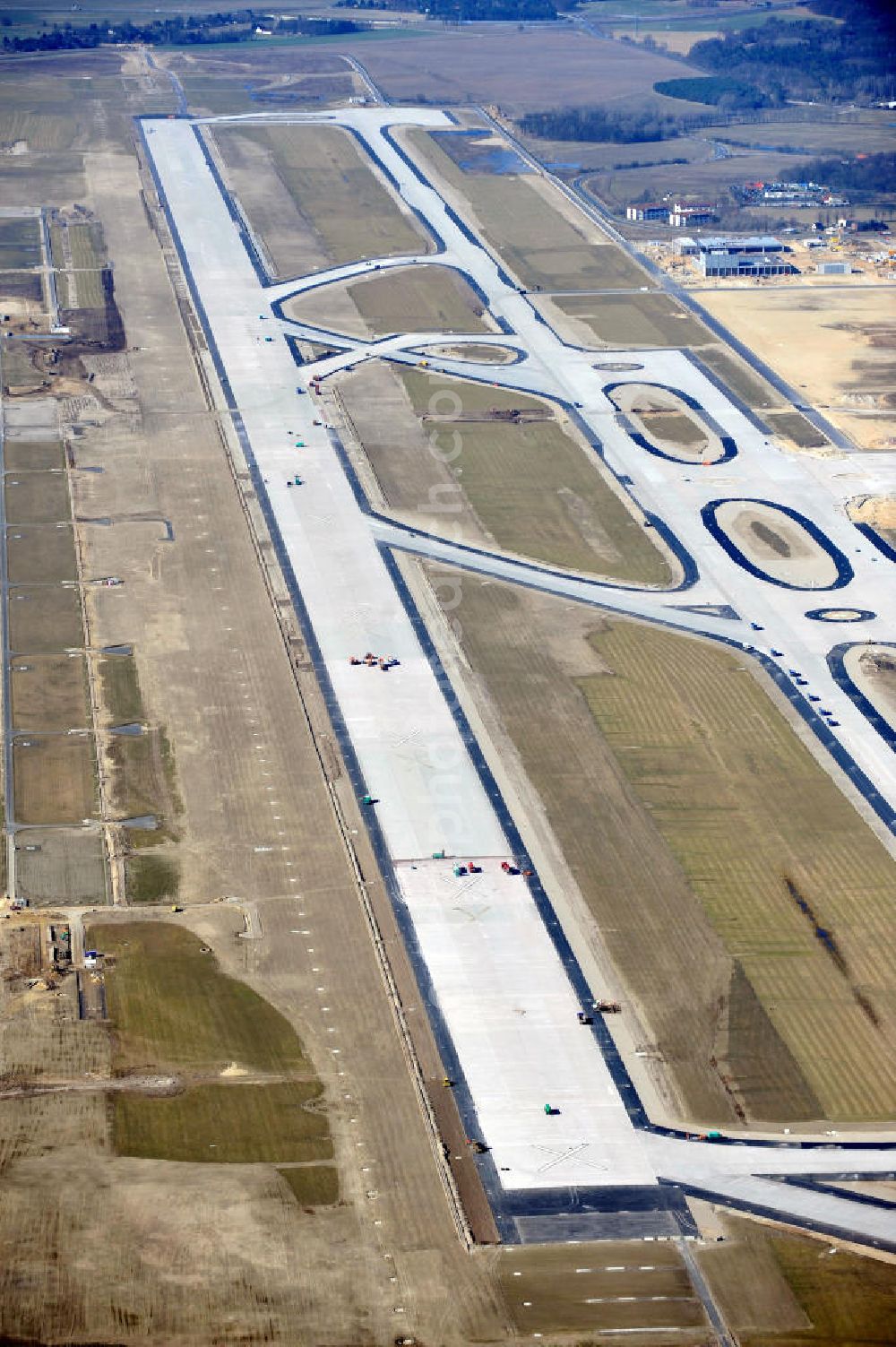 Schönefeld from the bird's eye view: Baustelle der neuen Start- und Landebahn des zukünftigen Flughafens BBI in Schönefeld. Ausführende Firmen: Hochtief AG, EUROVIA Beton, PORR, BERGER Bau, Kark Weiss, Matthai, Schäler Bau Berlin GmbH, STRABAG. Construction area of the new runway of the prospective Airport BBI in Schoenefeld.