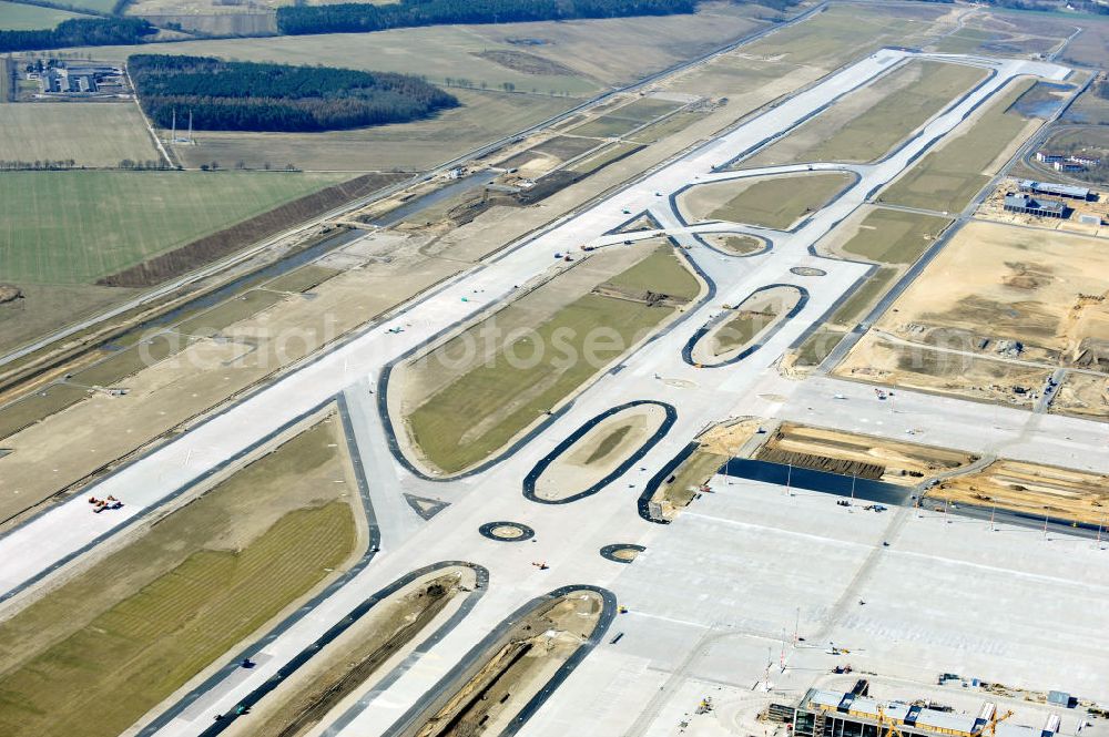 Aerial photograph Schönefeld - Baustelle der neuen Start- und Landebahn des zukünftigen Flughafens BBI in Schönefeld. Ausführende Firmen: Hochtief AG, EUROVIA Beton, PORR, BERGER Bau, Kark Weiss, Matthai, Schäler Bau Berlin GmbH, STRABAG. Construction area of the new runway of the prospective Airport BBI in Schoenefeld.