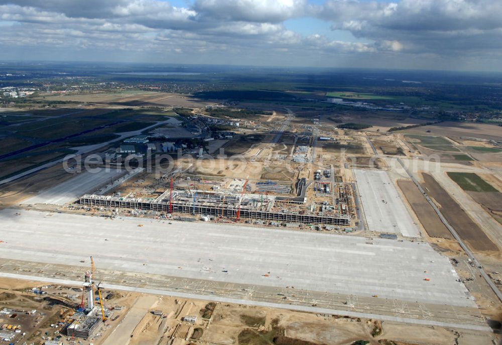 Schönefeld from the bird's eye view: Blick auf die Baustelle des neuen Fern- und S-Bahnhofes der Deutschen Bahn sowie das neue Terminal mit Vorfeld auf der Großbaustelle BBI (SXF) Flughafen Berlin-Schönefeld. Ausführende Firmen: Hochtief AG; EUROVIA Beton; PORR; BERGER Bau; Kark Weiss; Matthai; Schäler Bau Berlin GmbH; STRABAG; MAX BÖGL