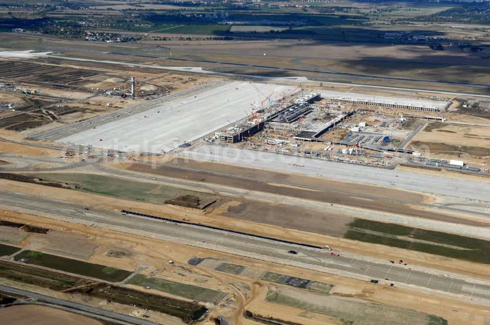 Schönefeld from the bird's eye view: Blick auf die Baustelle des neuen Fern- und S-Bahnhofes der Deutschen Bahn sowie das neue Terminal mit Vorfeld auf der Großbaustelle BBI (SXF) Flughafen Berlin-Schönefeld. Ausführende Firmen: Hochtief AG; EUROVIA Beton; PORR; BERGER Bau; Kark Weiss; Matthai; Schäler Bau Berlin GmbH; STRABAG; MAX BÖGL