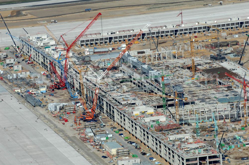 Schönefeld from the bird's eye view: Blick auf die Baustelle des neuen Fern- und S-Bahnhofes der Deutschen Bahn sowie das neue Terminal mit Vorfeld auf der Großbaustelle BBI (SXF) Flughafen Berlin-Schönefeld. Ausführende Firmen: Hochtief AG; EUROVIA Beton; PORR; BERGER Bau; Kark Weiss; Matthai; Schäler Bau Berlin GmbH; STRABAG; MAX BÖGL