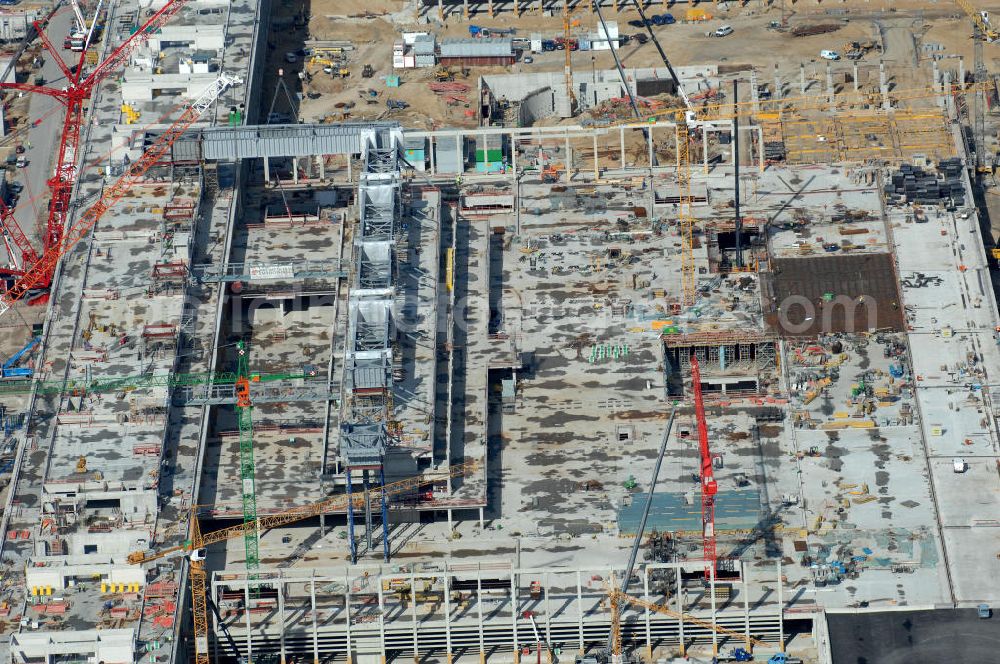 Schönefeld from the bird's eye view: Blick auf die Baustelle des neuen Fern- und S-Bahnhofes der Deutschen Bahn sowie das neue Terminal mit Vorfeld auf der Großbaustelle BBI (SXF) Flughafen Berlin-Schönefeld. Ausführende Firmen: Hochtief AG; EUROVIA Beton; PORR; BERGER Bau; Kark Weiss; Matthai; Schäler Bau Berlin GmbH; STRABAG; MAX BÖGL