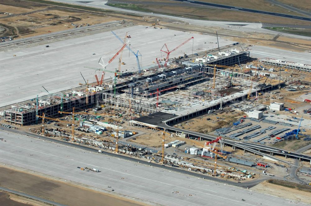 Aerial photograph Schönefeld - Blick auf die Baustelle des neuen Fern- und S-Bahnhofes der Deutschen Bahn sowie das neue Terminal mit Vorfeld auf der Großbaustelle BBI (SXF) Flughafen Berlin-Schönefeld. Ausführende Firmen: Hochtief AG; EUROVIA Beton; PORR; BERGER Bau; Kark Weiss; Matthai; Schäler Bau Berlin GmbH; STRABAG; MAX BÖGL