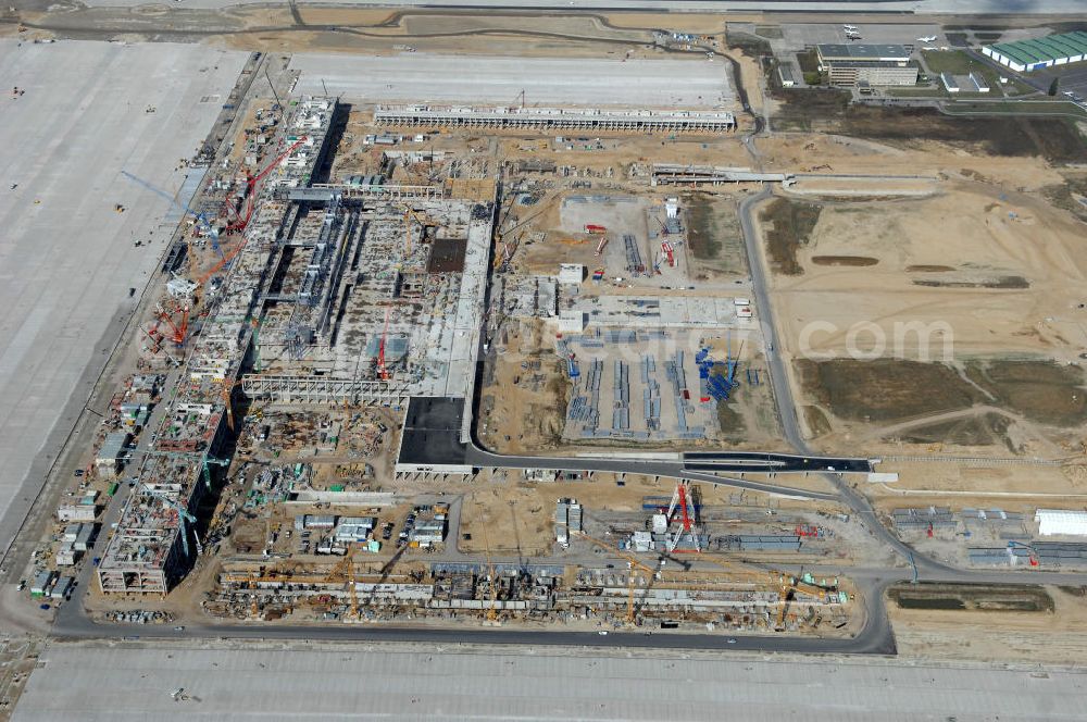 Schönefeld from the bird's eye view: Blick auf die Baustelle des neuen Fern- und S-Bahnhofes der Deutschen Bahn sowie das neue Terminal mit Vorfeld auf der Großbaustelle BBI (SXF) Flughafen Berlin-Schönefeld. Ausführende Firmen: Hochtief AG; EUROVIA Beton; PORR; BERGER Bau; Kark Weiss; Matthai; Schäler Bau Berlin GmbH; STRABAG; MAX BÖGL