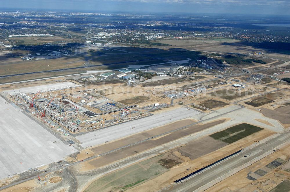 Schönefeld from the bird's eye view: Blick auf die Baustelle des neuen Fern- und S-Bahnhofes der Deutschen Bahn sowie das neue Terminal mit Vorfeld auf der Großbaustelle BBI (SXF) Flughafen Berlin-Schönefeld. Ausführende Firmen: Hochtief AG; EUROVIA Beton; PORR; BERGER Bau; Kark Weiss; Matthai; Schäler Bau Berlin GmbH; STRABAG; MAX BÖGL