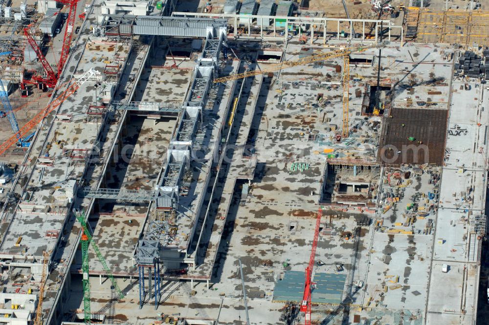 Schönefeld from the bird's eye view: Blick auf die Baustelle des neuen Fern- und S-Bahnhofes der Deutschen Bahn sowie das neue Terminal mit Vorfeld auf der Großbaustelle BBI (SXF) Flughafen Berlin-Schönefeld. Ausführende Firmen: Hochtief AG; EUROVIA Beton; PORR; BERGER Bau; Kark Weiss; Matthai; Schäler Bau Berlin GmbH; STRABAG; MAX BÖGL