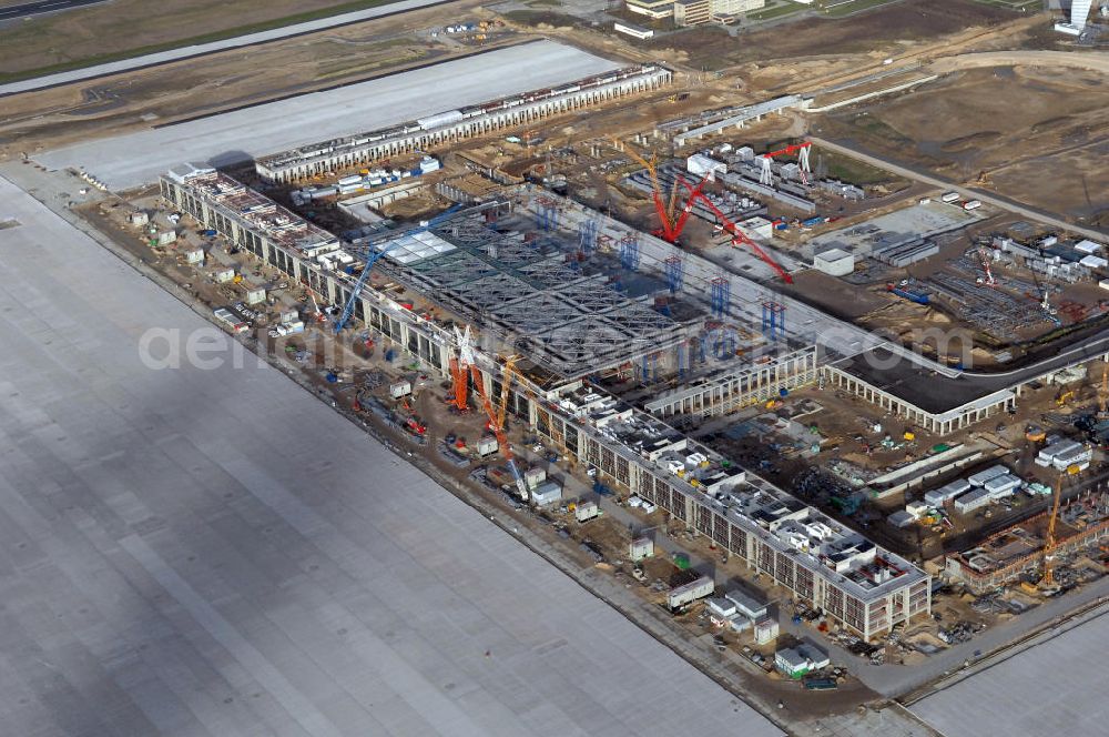 Schönefeld from the bird's eye view: Blick auf die Baustelle des neuen Fern- und S-Bahnhofes der Deutschen Bahn sowie das neue Terminal mit Vorfeld auf der Großbaustelle BBI (SXF) Flughafen Berlin-Schönefeld. Ausführende Firmen: Hochtief AG; EUROVIA Beton; PORR; BERGER Bau; Karl Weiss; Matthai; Schäler Bau Berlin GmbH; STRABAG; MAX BÖGL