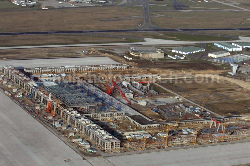 Schönefeld from the bird's eye view: Blick auf die Baustelle des neuen Fern- und S-Bahnhofes der Deutschen Bahn sowie das neue Terminal mit Vorfeld auf der Großbaustelle BBI (SXF) Flughafen Berlin-Schönefeld. Ausführende Firmen: Hochtief AG; EUROVIA Beton; PORR; BERGER Bau; Karl Weiss; Matthai; Schäler Bau Berlin GmbH; STRABAG; MAX BÖGL