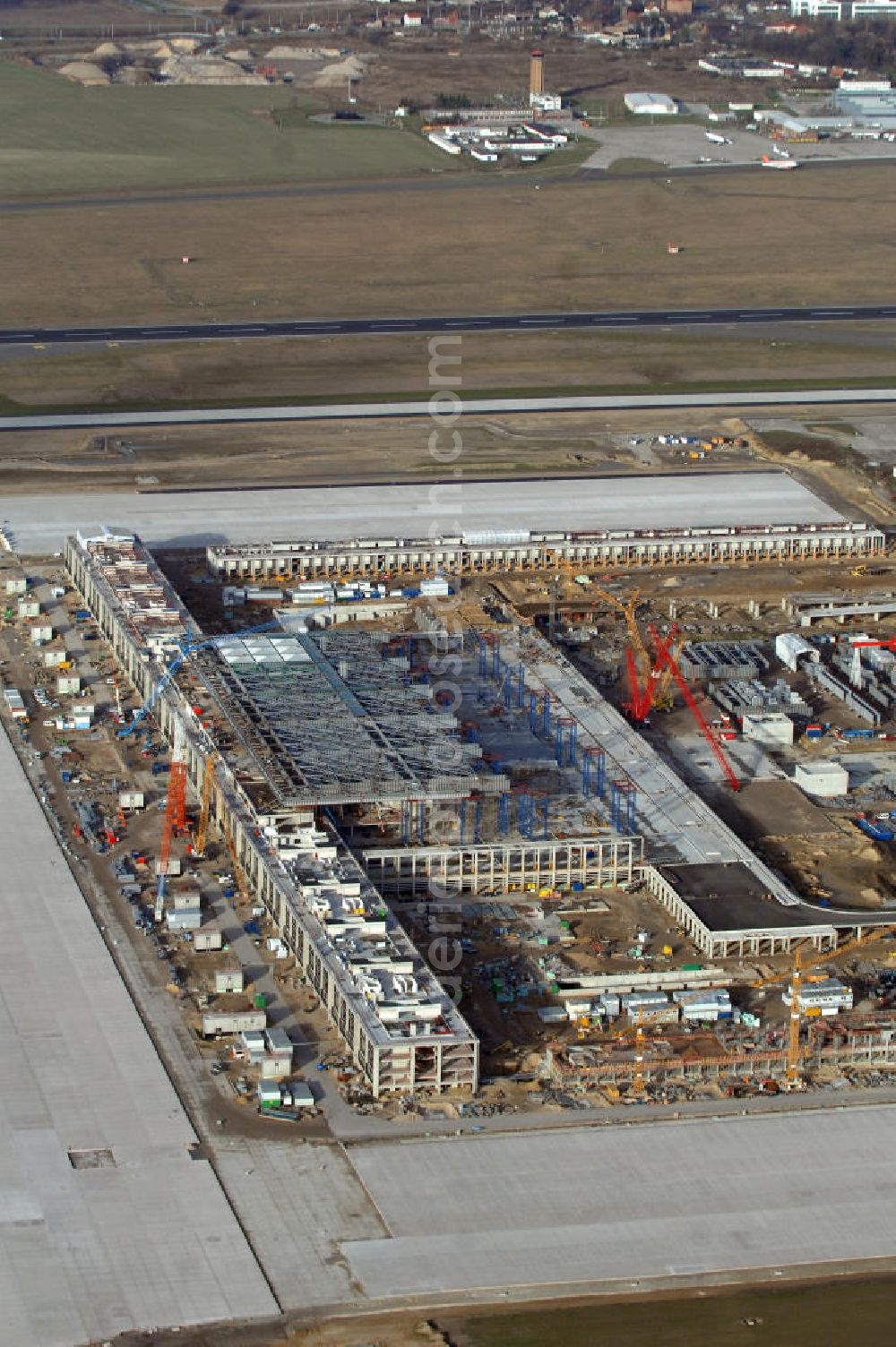 Aerial photograph Schönefeld - Blick auf die Baustelle des neuen Fern- und S-Bahnhofes der Deutschen Bahn sowie das neue Terminal mit Vorfeld auf der Großbaustelle BBI (SXF) Flughafen Berlin-Schönefeld. Ausführende Firmen: Hochtief AG; EUROVIA Beton; PORR; BERGER Bau; Karl Weiss; Matthai; Schäler Bau Berlin GmbH; STRABAG; MAX BÖGL