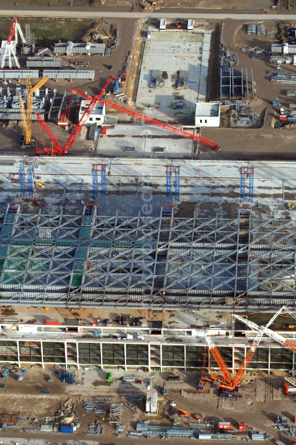 Aerial photograph Schönefeld - Blick auf die Baustelle des neuen Fern- und S-Bahnhofes der Deutschen Bahn sowie das neue Terminal mit Vorfeld auf der Großbaustelle BBI (SXF) Flughafen Berlin-Schönefeld. Ausführende Firmen: Hochtief AG; EUROVIA Beton; PORR; BERGER Bau; Karl Weiss; Matthai; Schäler Bau Berlin GmbH; STRABAG; MAX BÖGL