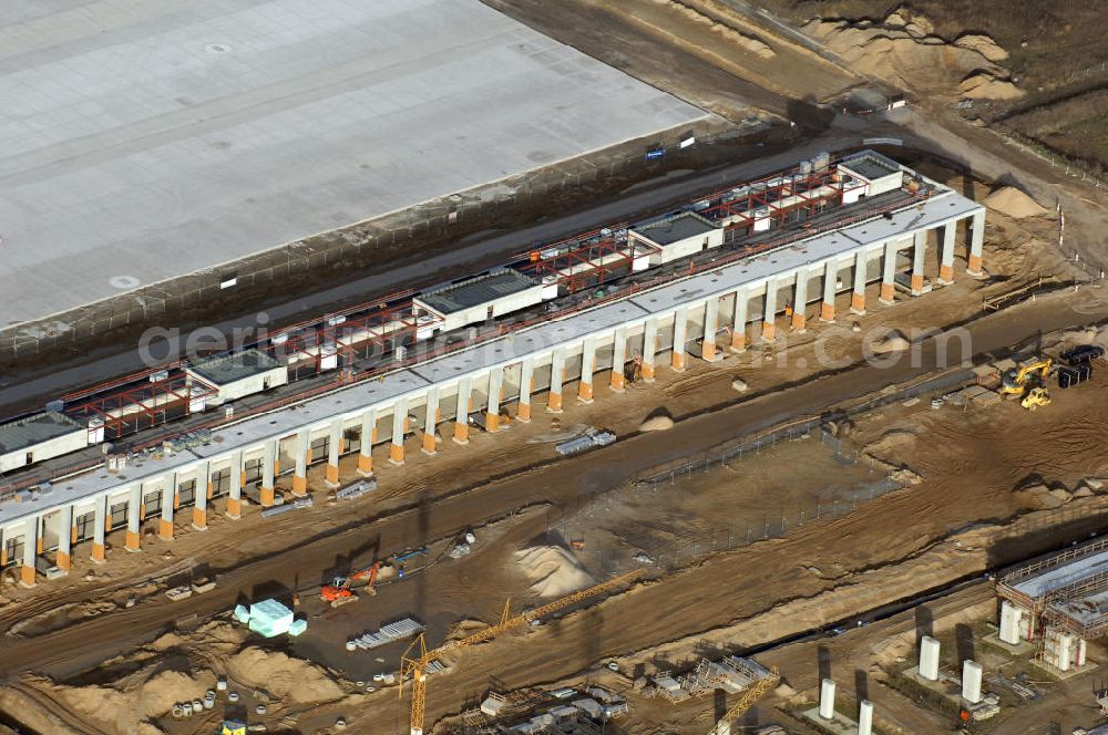 Schönefeld from the bird's eye view: Blick auf die Baustelle des neuen Fern- und S-Bahnhofes der Deutschen Bahn sowie das neue Terminal mit Vorfeld auf der Großbaustelle BBI (SXF) Flughafen Berlin-Schönefeld. Ausführende Firmen: Hochtief AG; EUROVIA Beton; PORR; BERGER Bau; Karl Weiss; Matthai; Schäler Bau Berlin GmbH; STRABAG; MAX BÖGL