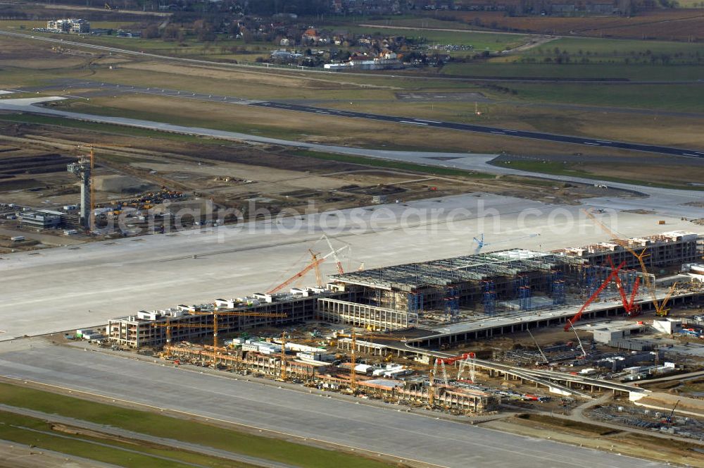 Schönefeld from the bird's eye view: Blick auf die Baustelle des neuen Fern- und S-Bahnhofes der Deutschen Bahn sowie das neue Terminal mit Vorfeld auf der Großbaustelle BBI (SXF) Flughafen Berlin-Schönefeld. Ausführende Firmen: Hochtief AG; EUROVIA Beton; PORR; BERGER Bau; Karl Weiss; Matthai; Schäler Bau Berlin GmbH; STRABAG; MAX BÖGL