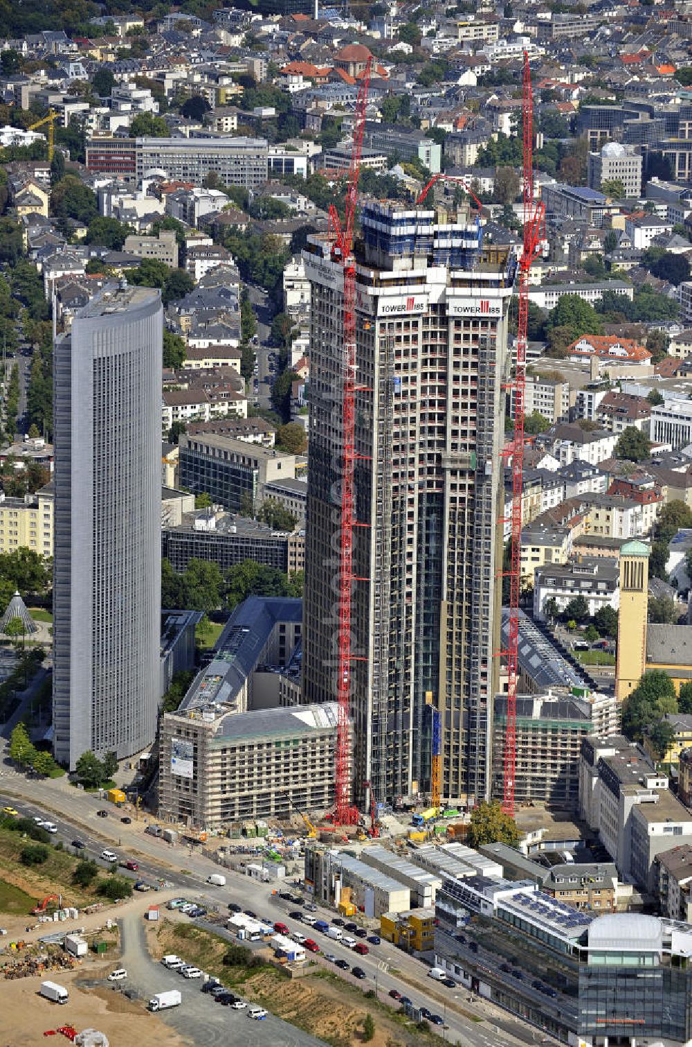 Frankfurt am Main from above - Blick auf die Baustelle des Tower 185 , dem derzeit höchstem, in Deutschland im Bau befindlichen Wolkenkratzer. Bauherr ist die Vivico Real Estate. Die Wirtschaftsprüfungsgesellschaft PricewaterhouseCoopers (PwC) hat bereits vor Baubeginn 60.000 Quadratmeter von insgesamt rund 90.000 Quadratmeter Bürofläche langfristig angemietet und wird hier ihre neue Deutschland-Zentrale beziehen. Den Entwurf für den Tower 185 lieferte der Frankfurter Architekt Christoph Mäckler. Er sieht ein hufeisenförmig angelegtes Sockelgebäude vor, aus dem sich die beiden Hochhaushälften mit einer Aluminium-Glas-Fassade erheben. View of the construction site of Tower 185, currently the highest skyscraper in Germany under construction. Owner is the Vivico real estate.