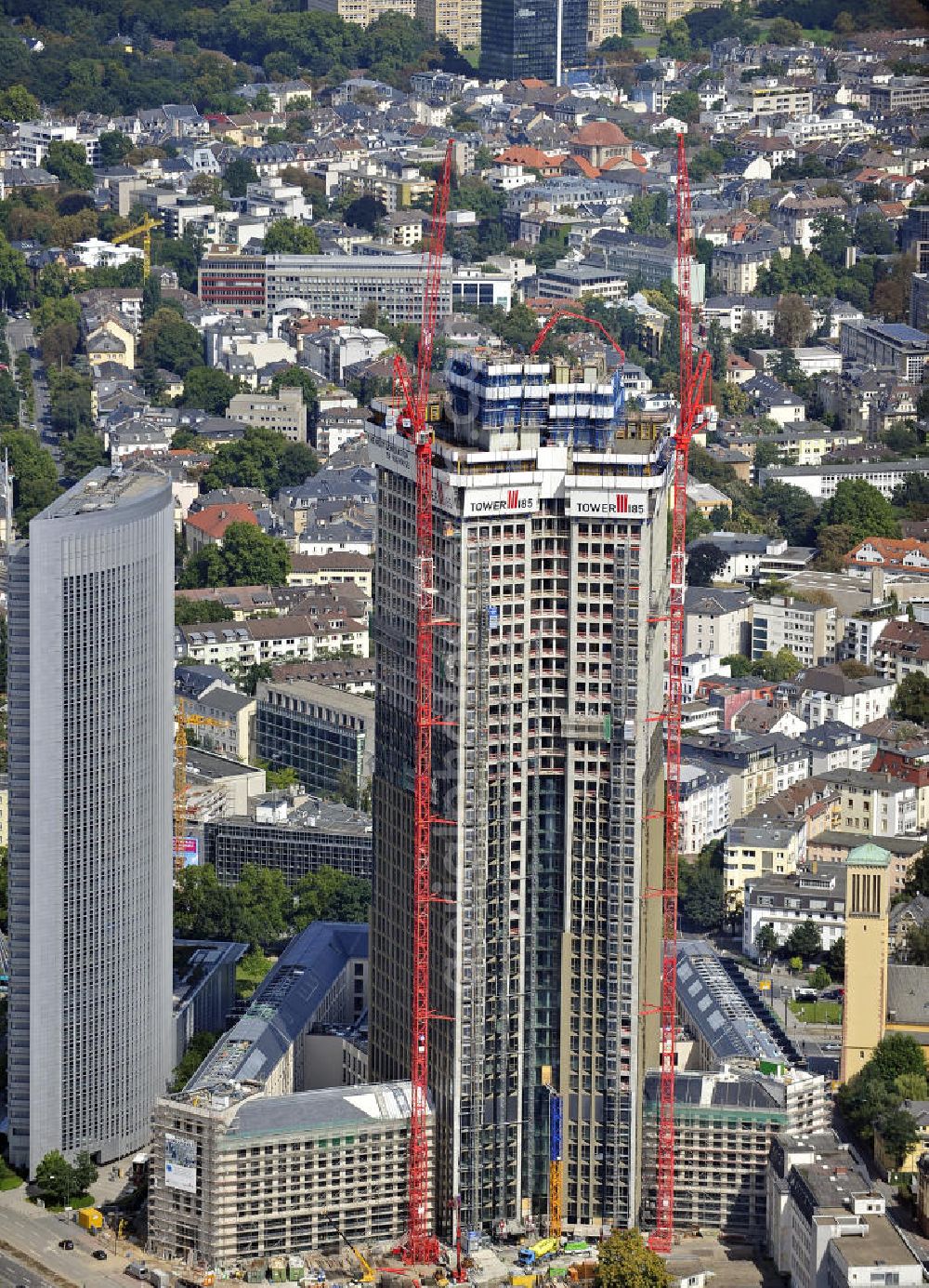 Aerial image Frankfurt am Main - Blick auf die Baustelle des Tower 185 , dem derzeit höchstem, in Deutschland im Bau befindlichen Wolkenkratzer. Bauherr ist die Vivico Real Estate. Die Wirtschaftsprüfungsgesellschaft PricewaterhouseCoopers (PwC) hat bereits vor Baubeginn 60.000 Quadratmeter von insgesamt rund 90.000 Quadratmeter Bürofläche langfristig angemietet und wird hier ihre neue Deutschland-Zentrale beziehen. Den Entwurf für den Tower 185 lieferte der Frankfurter Architekt Christoph Mäckler. Er sieht ein hufeisenförmig angelegtes Sockelgebäude vor, aus dem sich die beiden Hochhaushälften mit einer Aluminium-Glas-Fassade erheben. View of the construction site of Tower 185, currently the highest skyscraper in Germany under construction. Owner is the Vivico real estate.