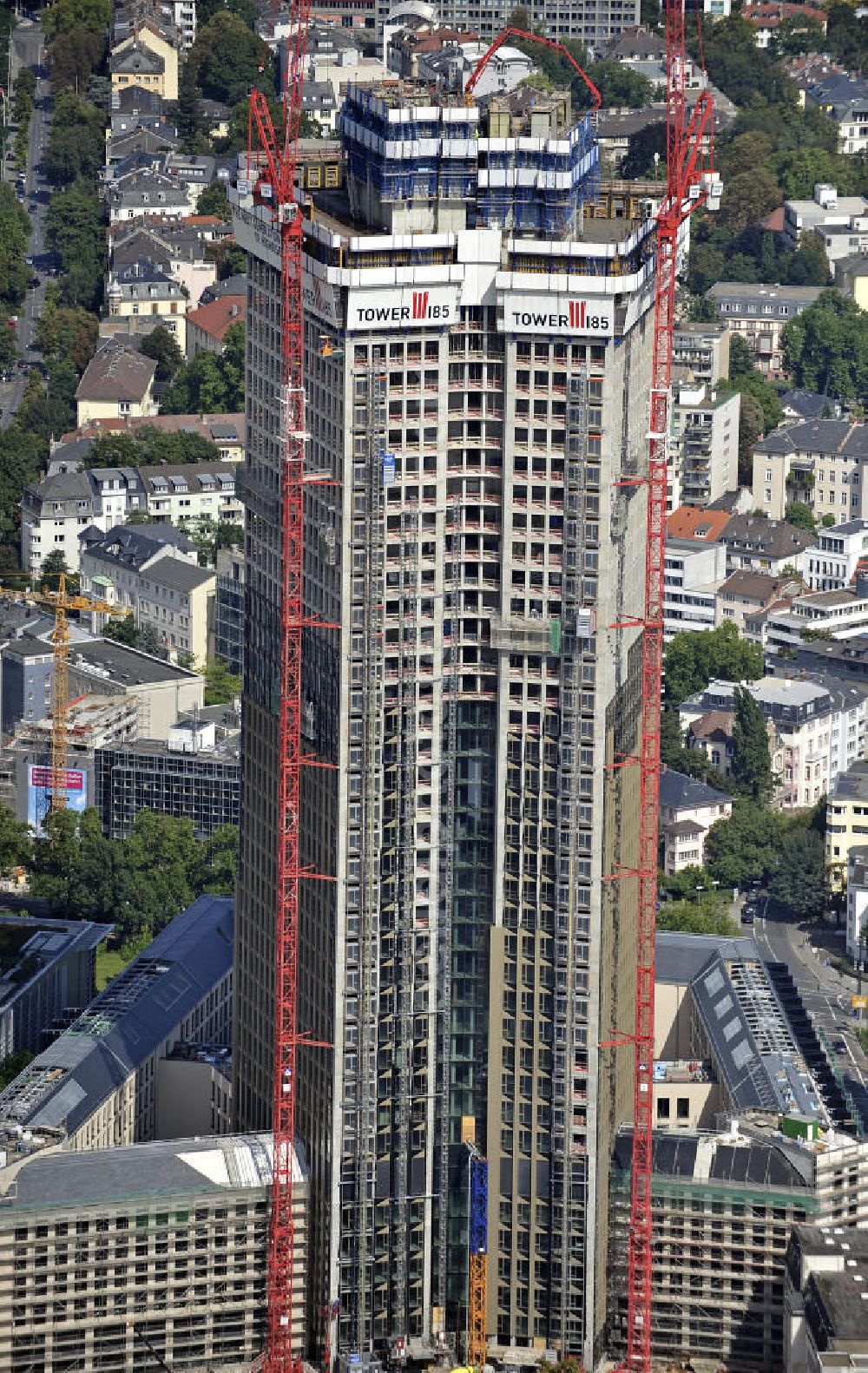 Frankfurt am Main from above - Blick auf die Baustelle des Tower 185 , dem derzeit höchstem, in Deutschland im Bau befindlichen Wolkenkratzer. Bauherr ist die Vivico Real Estate. Die Wirtschaftsprüfungsgesellschaft PricewaterhouseCoopers (PwC) hat bereits vor Baubeginn 60.000 Quadratmeter von insgesamt rund 90.000 Quadratmeter Bürofläche langfristig angemietet und wird hier ihre neue Deutschland-Zentrale beziehen. Den Entwurf für den Tower 185 lieferte der Frankfurter Architekt Christoph Mäckler. Er sieht ein hufeisenförmig angelegtes Sockelgebäude vor, aus dem sich die beiden Hochhaushälften mit einer Aluminium-Glas-Fassade erheben. View of the construction site of Tower 185, currently the highest skyscraper in Germany under construction. Owner is the Vivico real estate.