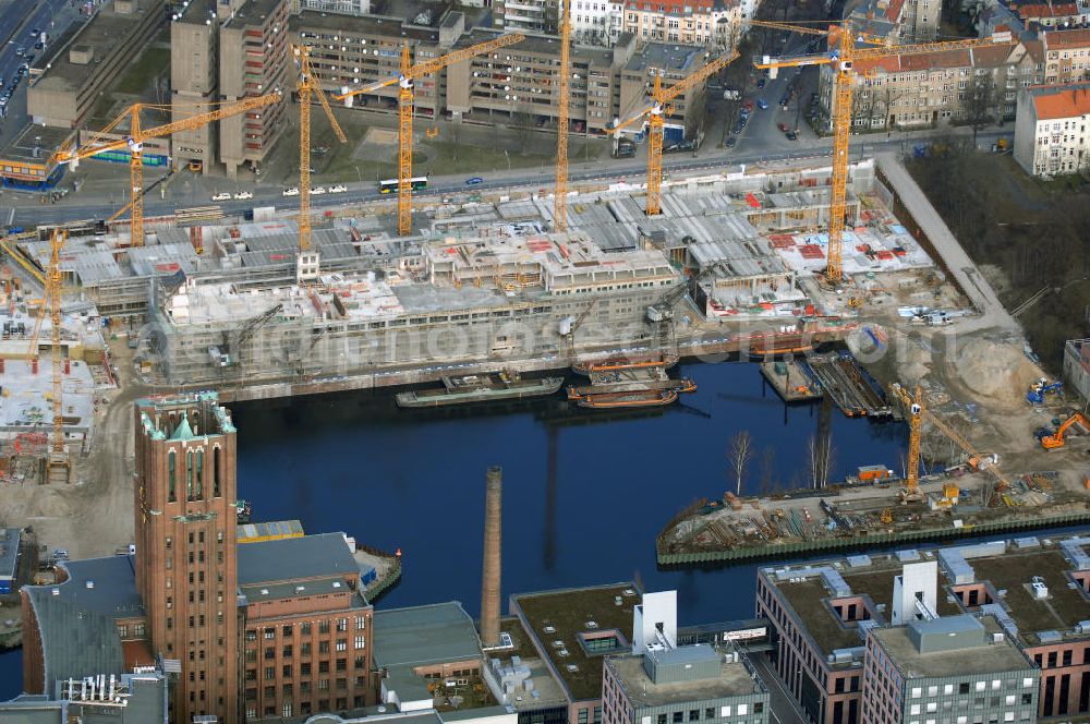 Aerial image Berlin - Blick auf die Baustelle vom Umbau Hafen Tempelhof am Ullsteinhaus. Der Tempelhofer Hafen entstand 1906 zusammen mit dem Teltowkanal. Zwei Jahre später kam der Speicher hinzu, eine der ersten Stahlbetonbauten in Deutschland. Im Krieg wurde das Gebäude schwer zerstört. Nach dem Wiederaufbau lagerte dort ein Teil der Lebensmittel-Reserve für West-Berlin. Bis zum Herbst 2008 sollen neben einer Einzelhandelsfläche von knapp 20 000 Quadratmetern und eine Fläche von etwa 10000 Quadratmeter für Unterhaltung, Grünflächen und Flanierwege entstehen. Hierfür wird der alte Speicher von einem Neubau flankiert. Etwa 70 Geschäfte haben in beiden Gebäuden Platz. Auf dem Dach des Neubaus entstehen 600 Parkplätze. Der Hafen selbst bleibt exklusiv Fußgängern und Freizeitkapitänen vorbehalten. Adresse: Ordensmeisterstraße, 12099 Berlin-Tempelhof; Kontakt Architekt: REM+tec Architekten, Gesellschaft für Projektentwicklung und Denkmalschutz mbH, Kurfürstenstraße 132, 10785 Berlin,Tel. 030 264767-70, Fax 030 264767-47, info@remtec.eu,