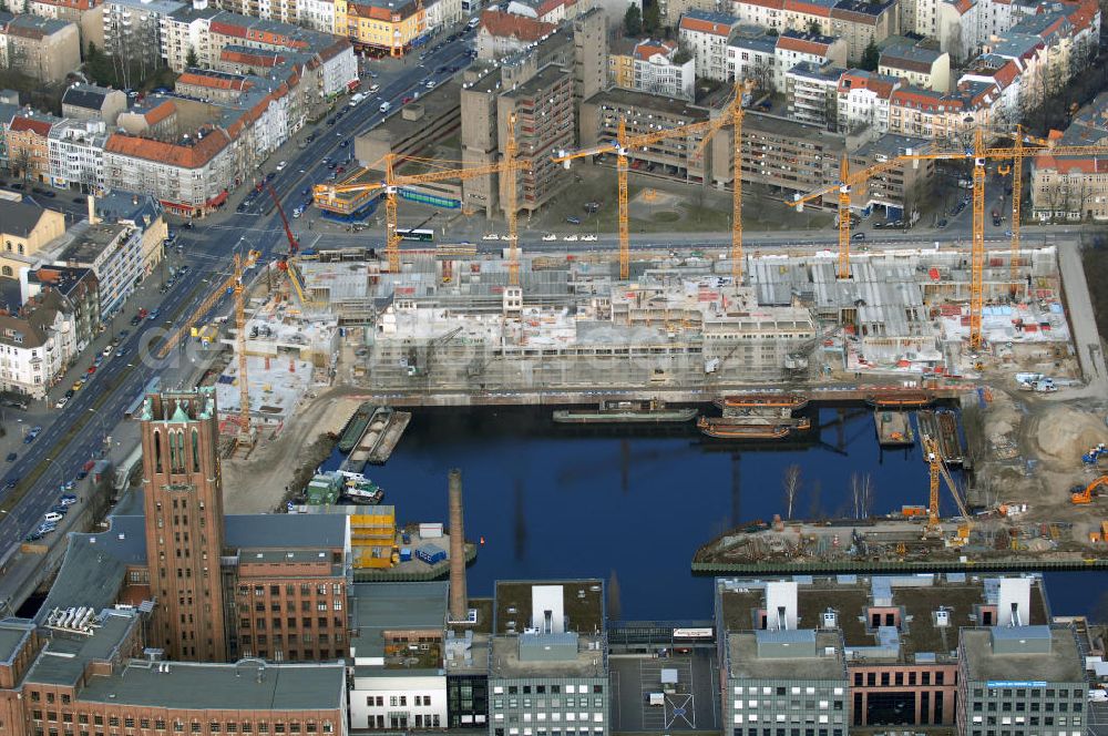 Berlin from above - Blick auf die Baustelle vom Umbau Hafen Tempelhof am Ullsteinhaus. Der Tempelhofer Hafen entstand 1906 zusammen mit dem Teltowkanal. Zwei Jahre später kam der Speicher hinzu, eine der ersten Stahlbetonbauten in Deutschland. Im Krieg wurde das Gebäude schwer zerstört. Nach dem Wiederaufbau lagerte dort ein Teil der Lebensmittel-Reserve für West-Berlin. Bis zum Herbst 2008 sollen neben einer Einzelhandelsfläche von knapp 20 000 Quadratmetern und eine Fläche von etwa 10000 Quadratmeter für Unterhaltung, Grünflächen und Flanierwege entstehen. Hierfür wird der alte Speicher von einem Neubau flankiert. Etwa 70 Geschäfte haben in beiden Gebäuden Platz. Auf dem Dach des Neubaus entstehen 600 Parkplätze. Der Hafen selbst bleibt exklusiv Fußgängern und Freizeitkapitänen vorbehalten. Adresse: Ordensmeisterstraße, 12099 Berlin-Tempelhof; Kontakt Architekt: REM+tec Architekten, Gesellschaft für Projektentwicklung und Denkmalschutz mbH, Kurfürstenstraße 132, 10785 Berlin,Tel. 030 264767-70, Fax 030 264767-47, info@remtec.eu,