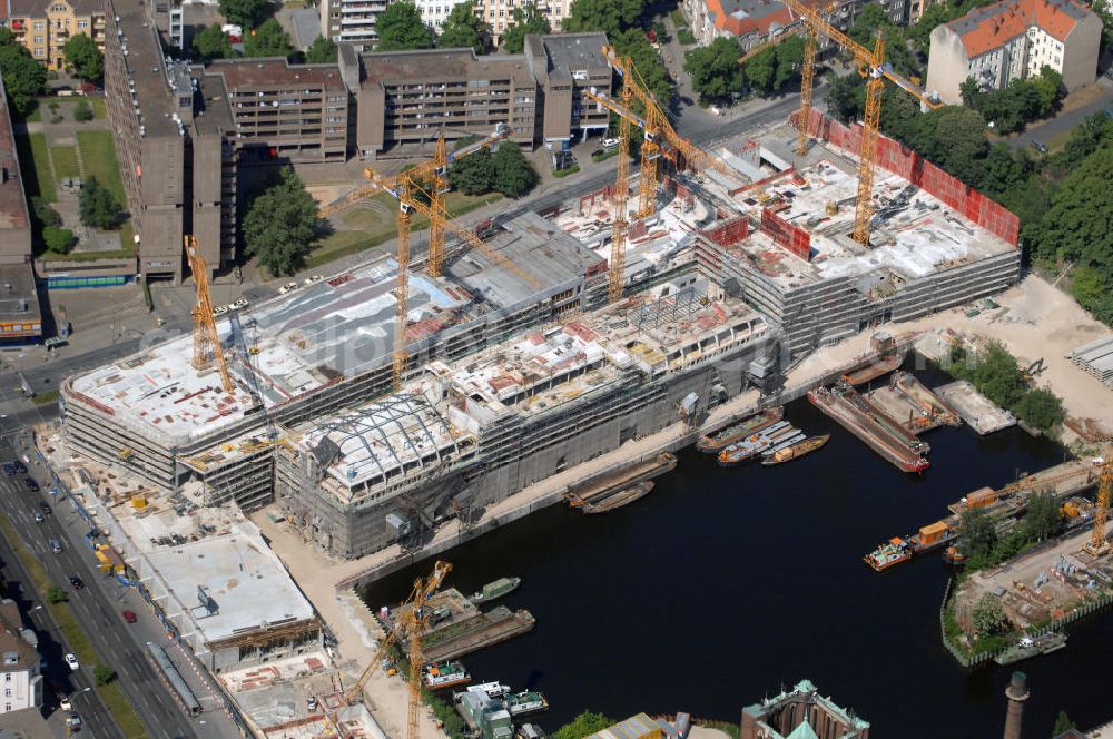 Aerial photograph Berlin - Blick auf die Baustelle vom Umbau Hafen Tempelhof am Ullsteinhaus. Der Tempelhofer Hafen entstand 1906 zusammen mit dem Teltowkanal. Zwei Jahre später kam der Speicher hinzu, eine der ersten Stahlbetonbauten in Deutschland. Im Krieg wurde das Gebäude schwer zerstört. Nach dem Wiederaufbau lagerte dort ein Teil der Lebensmittel-Reserve für West-Berlin. Bis zum Herbst 2008 sollen neben einer Einzelhandelsfläche von knapp 20 000 Quadratmetern und eine Fläche von etwa 10000 Quadratmeter für Unterhaltung, Grünflächen und Flanierwege entstehen. Hierfür wird der alte Speicher von einem Neubau flankiert. Etwa 70 Geschäfte haben in beiden Gebäuden Platz. Auf dem Dach des Neubaus entstehen 600 Parkplätze. Der Hafen selbst bleibt exklusiv Fußgängern und Freizeitkapitänen vorbehalten. Adresse: Ordensmeisterstraße, 12099 Berlin-Tempelhof; Kontakt Architekt: REM+tec Architekten, Gesellschaft für Projektentwicklung und Denkmalschutz mbH, Kurfürstenstraße 132, 10785 Berlin,Tel. 030 264767-70, Fax 030 264767-47, info@remtec.eu,