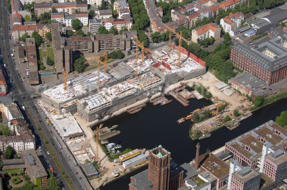 Berlin from above - Blick auf die Baustelle vom Umbau Hafen Tempelhof am Ullsteinhaus. Der Tempelhofer Hafen entstand 1906 zusammen mit dem Teltowkanal. Zwei Jahre später kam der Speicher hinzu, eine der ersten Stahlbetonbauten in Deutschland. Im Krieg wurde das Gebäude schwer zerstört. Nach dem Wiederaufbau lagerte dort ein Teil der Lebensmittel-Reserve für West-Berlin. Bis zum Herbst 2008 sollen neben einer Einzelhandelsfläche von knapp 20 000 Quadratmetern und eine Fläche von etwa 10000 Quadratmeter für Unterhaltung, Grünflächen und Flanierwege entstehen. Hierfür wird der alte Speicher von einem Neubau flankiert. Etwa 70 Geschäfte haben in beiden Gebäuden Platz. Auf dem Dach des Neubaus entstehen 600 Parkplätze. Der Hafen selbst bleibt exklusiv Fußgängern und Freizeitkapitänen vorbehalten. Adresse: Ordensmeisterstraße, 12099 Berlin-Tempelhof; Kontakt Architekt: REM+tec Architekten, Gesellschaft für Projektentwicklung und Denkmalschutz mbH, Kurfürstenstraße 132, 10785 Berlin,Tel. 030 264767-70, Fax 030 264767-47, info@remtec.eu,