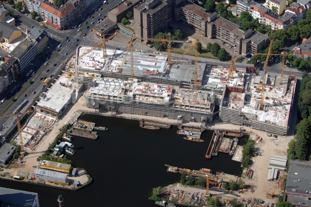 Berlin from the bird's eye view: Blick auf die Baustelle vom Umbau Hafen Tempelhof am Ullsteinhaus. Der Tempelhofer Hafen entstand 1906 zusammen mit dem Teltowkanal. Zwei Jahre später kam der Speicher hinzu, eine der ersten Stahlbetonbauten in Deutschland. Im Krieg wurde das Gebäude schwer zerstört. Nach dem Wiederaufbau lagerte dort ein Teil der Lebensmittel-Reserve für West-Berlin. Bis zum Herbst 2008 sollen neben einer Einzelhandelsfläche von knapp 20 000 Quadratmetern und eine Fläche von etwa 10000 Quadratmeter für Unterhaltung, Grünflächen und Flanierwege entstehen. Hierfür wird der alte Speicher von einem Neubau flankiert. Etwa 70 Geschäfte haben in beiden Gebäuden Platz. Auf dem Dach des Neubaus entstehen 600 Parkplätze. Der Hafen selbst bleibt exklusiv Fußgängern und Freizeitkapitänen vorbehalten. Adresse: Ordensmeisterstraße, 12099 Berlin-Tempelhof; Kontakt Architekt: REM+tec Architekten, Gesellschaft für Projektentwicklung und Denkmalschutz mbH, Kurfürstenstraße 132, 10785 Berlin,Tel. 030 264767-70, Fax 030 264767-47, info@remtec.eu,