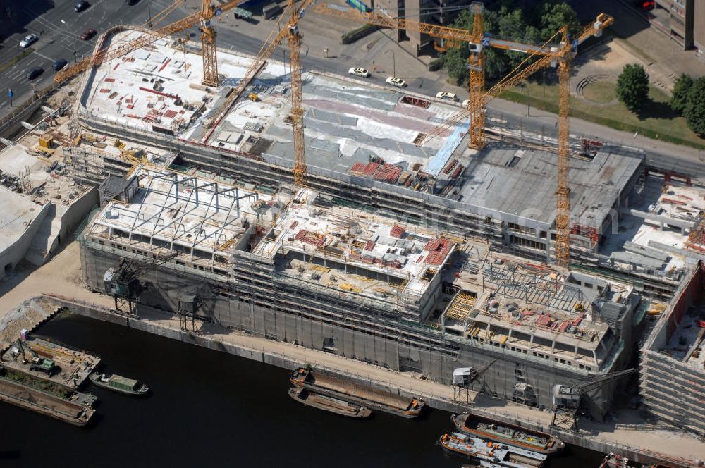 Aerial image Berlin - Blick auf die Baustelle vom Umbau Hafen Tempelhof am Ullsteinhaus. Der Tempelhofer Hafen entstand 1906 zusammen mit dem Teltowkanal. Zwei Jahre später kam der Speicher hinzu, eine der ersten Stahlbetonbauten in Deutschland. Im Krieg wurde das Gebäude schwer zerstört. Nach dem Wiederaufbau lagerte dort ein Teil der Lebensmittel-Reserve für West-Berlin. Bis zum Herbst 2008 sollen neben einer Einzelhandelsfläche von knapp 20 000 Quadratmetern und eine Fläche von etwa 10000 Quadratmeter für Unterhaltung, Grünflächen und Flanierwege entstehen. Hierfür wird der alte Speicher von einem Neubau flankiert. Etwa 70 Geschäfte haben in beiden Gebäuden Platz. Auf dem Dach des Neubaus entstehen 600 Parkplätze. Der Hafen selbst bleibt exklusiv Fußgängern und Freizeitkapitänen vorbehalten. Adresse: Ordensmeisterstraße, 12099 Berlin-Tempelhof; Kontakt Architekt: REM+tec Architekten, Gesellschaft für Projektentwicklung und Denkmalschutz mbH, Kurfürstenstraße 132, 10785 Berlin,Tel. 030 264767-70, Fax 030 264767-47, info@remtec.eu,