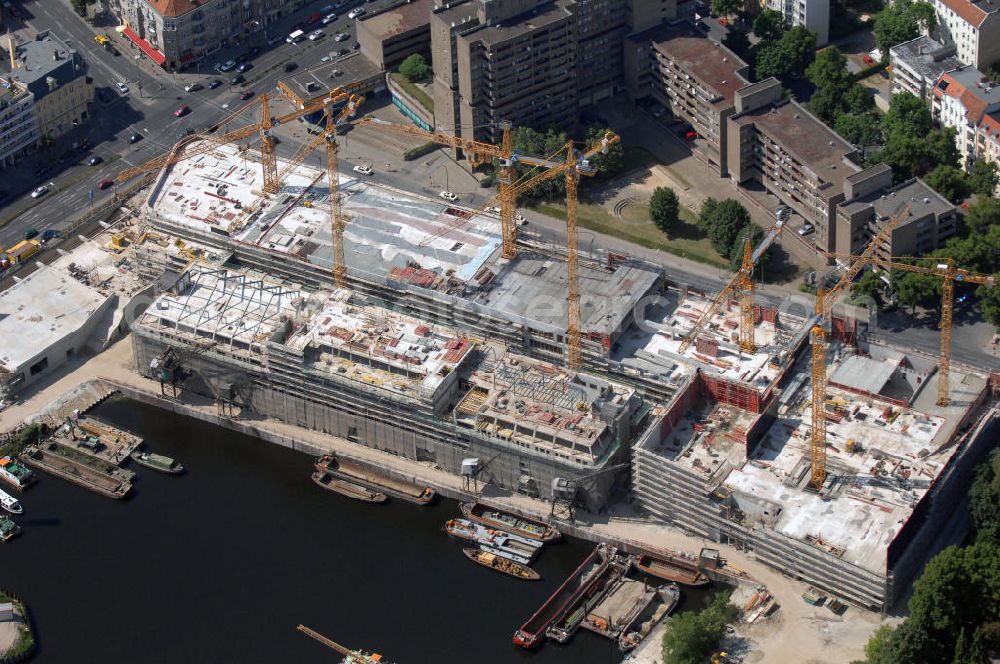 Aerial photograph Berlin - Blick auf die Baustelle vom Umbau Hafen Tempelhof am Ullsteinhaus. Der Tempelhofer Hafen entstand 1906 zusammen mit dem Teltowkanal. Zwei Jahre später kam der Speicher hinzu, eine der ersten Stahlbetonbauten in Deutschland. Im Krieg wurde das Gebäude schwer zerstört. Nach dem Wiederaufbau lagerte dort ein Teil der Lebensmittel-Reserve für West-Berlin. Bis zum Herbst 2008 sollen neben einer Einzelhandelsfläche von knapp 20 000 Quadratmetern und eine Fläche von etwa 10000 Quadratmeter für Unterhaltung, Grünflächen und Flanierwege entstehen. Hierfür wird der alte Speicher von einem Neubau flankiert. Etwa 70 Geschäfte haben in beiden Gebäuden Platz. Auf dem Dach des Neubaus entstehen 600 Parkplätze. Der Hafen selbst bleibt exklusiv Fußgängern und Freizeitkapitänen vorbehalten. Adresse: Ordensmeisterstraße, 12099 Berlin-Tempelhof; Kontakt Architekt: REM+tec Architekten, Gesellschaft für Projektentwicklung und Denkmalschutz mbH, Kurfürstenstraße 132, 10785 Berlin,Tel. 030 264767-70, Fax 030 264767-47, info@remtec.eu,