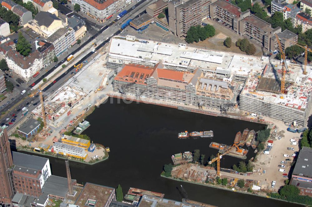 Berlin from above - Blick auf die Baustelle vom Umbau Hafen Tempelhof am Ullsteinhaus. Der Tempelhofer Hafen entstand 1906 zusammen mit dem Teltowkanal. Zwei Jahre später kam der Speicher hinzu, eine der ersten Stahlbetonbauten in Deutschland. Im Krieg wurde das Gebäude schwer zerstört. Nach dem Wiederaufbau lagerte dort ein Teil der Lebensmittel-Reserve für West-Berlin. Bis zum Herbst 2008 sollen neben einer Einzelhandelsfläche von knapp 20 000 Quadratmetern und eine Fläche von etwa 10000 Quadratmeter für Unterhaltung, Grünflächen und Flanierwege entstehen. Hierfür wird der alte Speicher von einem Neubau flankiert. Etwa 70 Geschäfte haben in beiden Gebäuden Platz. Auf dem Dach des Neubaus entstehen 600 Parkplätze. Der Hafen selbst bleibt exklusiv Fußgängern und Freizeitkapitänen vorbehalten. Adresse: Ordensmeisterstraße, 12099 Berlin-Tempelhof; Kontakt Architekt: REM+tec Architekten, Gesellschaft für Projektentwicklung und Denkmalschutz mbH, Kurfürstenstraße 132, 10785 Berlin,Tel. 030 264767-70, Fax 030 264767-47, info@remtec.eu,