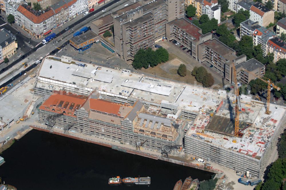 Berlin from the bird's eye view: Blick auf die Baustelle vom Umbau Hafen Tempelhof am Ullsteinhaus. Der Tempelhofer Hafen entstand 1906 zusammen mit dem Teltowkanal. Zwei Jahre später kam der Speicher hinzu, eine der ersten Stahlbetonbauten in Deutschland. Im Krieg wurde das Gebäude schwer zerstört. Nach dem Wiederaufbau lagerte dort ein Teil der Lebensmittel-Reserve für West-Berlin. Bis zum Herbst 2008 sollen neben einer Einzelhandelsfläche von knapp 20 000 Quadratmetern und eine Fläche von etwa 10000 Quadratmeter für Unterhaltung, Grünflächen und Flanierwege entstehen. Hierfür wird der alte Speicher von einem Neubau flankiert. Etwa 70 Geschäfte haben in beiden Gebäuden Platz. Auf dem Dach des Neubaus entstehen 600 Parkplätze. Der Hafen selbst bleibt exklusiv Fußgängern und Freizeitkapitänen vorbehalten. Adresse: Ordensmeisterstraße, 12099 Berlin-Tempelhof; Kontakt Architekt: REM+tec Architekten, Gesellschaft für Projektentwicklung und Denkmalschutz mbH, Kurfürstenstraße 132, 10785 Berlin,Tel. 030 264767-70, Fax 030 264767-47, info@remtec.eu,