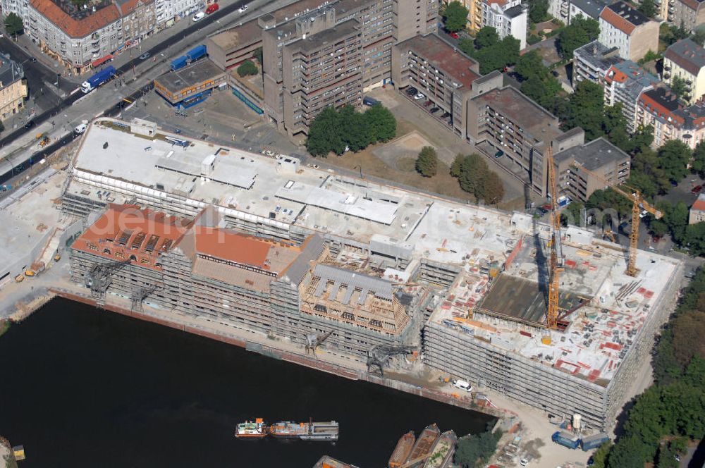 Aerial image Berlin - Blick auf die Baustelle vom Umbau Hafen Tempelhof am Ullsteinhaus. Der Tempelhofer Hafen entstand 1906 zusammen mit dem Teltowkanal. Zwei Jahre später kam der Speicher hinzu, eine der ersten Stahlbetonbauten in Deutschland. Im Krieg wurde das Gebäude schwer zerstört. Nach dem Wiederaufbau lagerte dort ein Teil der Lebensmittel-Reserve für West-Berlin. Bis zum Herbst 2008 sollen neben einer Einzelhandelsfläche von knapp 20 000 Quadratmetern und eine Fläche von etwa 10000 Quadratmeter für Unterhaltung, Grünflächen und Flanierwege entstehen. Hierfür wird der alte Speicher von einem Neubau flankiert. Etwa 70 Geschäfte haben in beiden Gebäuden Platz. Auf dem Dach des Neubaus entstehen 600 Parkplätze. Der Hafen selbst bleibt exklusiv Fußgängern und Freizeitkapitänen vorbehalten. Adresse: Ordensmeisterstraße, 12099 Berlin-Tempelhof; Kontakt Architekt: REM+tec Architekten, Gesellschaft für Projektentwicklung und Denkmalschutz mbH, Kurfürstenstraße 132, 10785 Berlin,Tel. 030 264767-70, Fax 030 264767-47, info@remtec.eu,