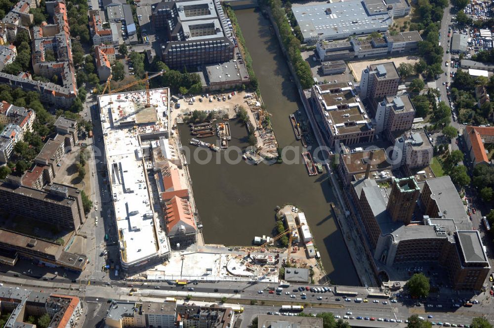 Aerial photograph Berlin - Blick auf die Baustelle vom Umbau Hafen Tempelhof am Ullsteinhaus. Der Tempelhofer Hafen entstand 1906 zusammen mit dem Teltowkanal. Zwei Jahre später kam der Speicher hinzu, eine der ersten Stahlbetonbauten in Deutschland. Im Krieg wurde das Gebäude schwer zerstört. Nach dem Wiederaufbau lagerte dort ein Teil der Lebensmittel-Reserve für West-Berlin. Bis zum Herbst 2008 sollen neben einer Einzelhandelsfläche von knapp 20 000 Quadratmetern und eine Fläche von etwa 10000 Quadratmeter für Unterhaltung, Grünflächen und Flanierwege entstehen. Hierfür wird der alte Speicher von einem Neubau flankiert. Etwa 70 Geschäfte haben in beiden Gebäuden Platz. Auf dem Dach des Neubaus entstehen 600 Parkplätze. Der Hafen selbst bleibt exklusiv Fußgängern und Freizeitkapitänen vorbehalten. Adresse: Ordensmeisterstraße, 12099 Berlin-Tempelhof; Kontakt Architekt: REM+tec Architekten, Gesellschaft für Projektentwicklung und Denkmalschutz mbH, Kurfürstenstraße 132, 10785 Berlin,Tel. 030 264767-70, Fax 030 264767-47, info@remtec.eu,