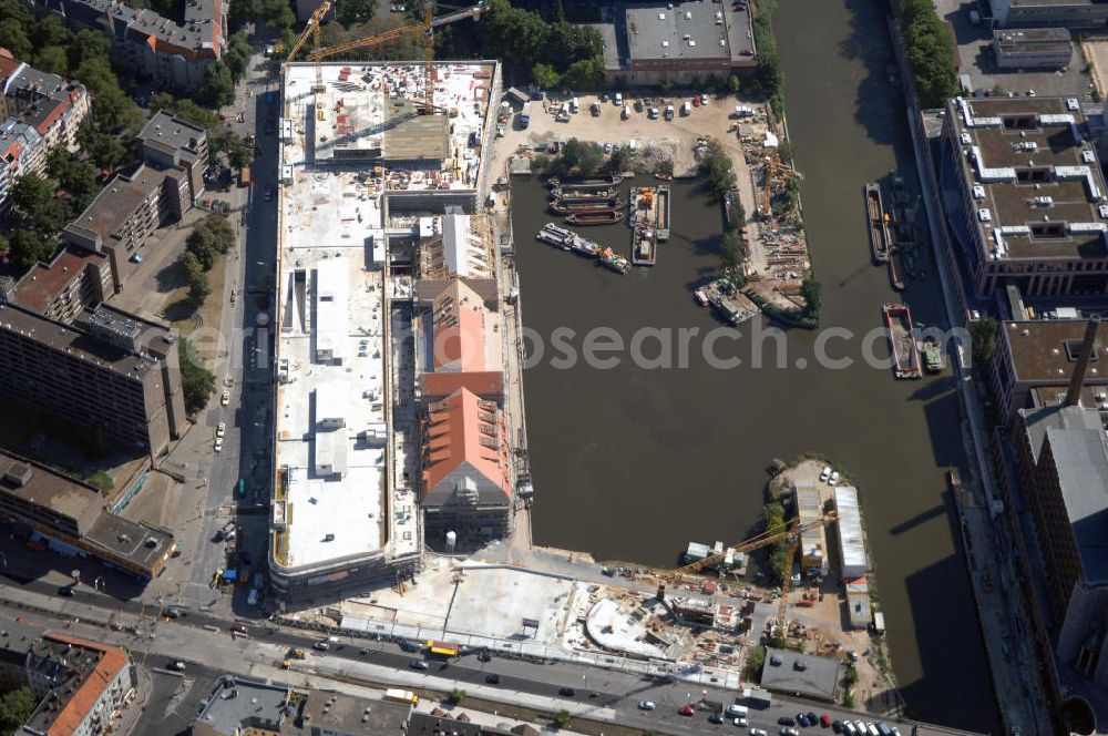 Berlin from above - Blick auf die Baustelle vom Umbau Hafen Tempelhof am Ullsteinhaus. Der Tempelhofer Hafen entstand 1906 zusammen mit dem Teltowkanal. Zwei Jahre später kam der Speicher hinzu, eine der ersten Stahlbetonbauten in Deutschland. Im Krieg wurde das Gebäude schwer zerstört. Nach dem Wiederaufbau lagerte dort ein Teil der Lebensmittel-Reserve für West-Berlin. Bis zum Herbst 2008 sollen neben einer Einzelhandelsfläche von knapp 20 000 Quadratmetern und eine Fläche von etwa 10000 Quadratmeter für Unterhaltung, Grünflächen und Flanierwege entstehen. Hierfür wird der alte Speicher von einem Neubau flankiert. Etwa 70 Geschäfte haben in beiden Gebäuden Platz. Auf dem Dach des Neubaus entstehen 600 Parkplätze. Der Hafen selbst bleibt exklusiv Fußgängern und Freizeitkapitänen vorbehalten. Adresse: Ordensmeisterstraße, 12099 Berlin-Tempelhof; Kontakt Architekt: REM+tec Architekten, Gesellschaft für Projektentwicklung und Denkmalschutz mbH, Kurfürstenstraße 132, 10785 Berlin,Tel. 030 264767-70, Fax 030 264767-47, info@remtec.eu,