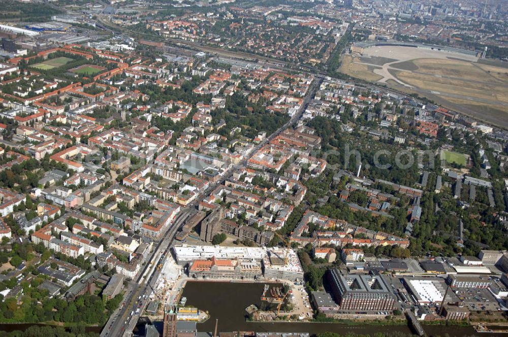 Berlin from above - Blick auf die Baustelle vom Umbau Hafen Tempelhof am Ullsteinhaus. Der Tempelhofer Hafen entstand 1906 zusammen mit dem Teltowkanal. Zwei Jahre später kam der Speicher hinzu, eine der ersten Stahlbetonbauten in Deutschland. Im Krieg wurde das Gebäude schwer zerstört. Nach dem Wiederaufbau lagerte dort ein Teil der Lebensmittel-Reserve für West-Berlin. Bis zum Herbst 2008 sollen neben einer Einzelhandelsfläche von knapp 20 000 Quadratmetern und eine Fläche von etwa 10000 Quadratmeter für Unterhaltung, Grünflächen und Flanierwege entstehen. Hierfür wird der alte Speicher von einem Neubau flankiert. Etwa 70 Geschäfte haben in beiden Gebäuden Platz. Auf dem Dach des Neubaus entstehen 600 Parkplätze. Der Hafen selbst bleibt exklusiv Fußgängern und Freizeitkapitänen vorbehalten. Adresse: Ordensmeisterstraße, 12099 Berlin-Tempelhof; Kontakt Architekt: REM+tec Architekten, Gesellschaft für Projektentwicklung und Denkmalschutz mbH, Kurfürstenstraße 132, 10785 Berlin,Tel. 030 264767-70, Fax 030 264767-47, info@remtec.eu,