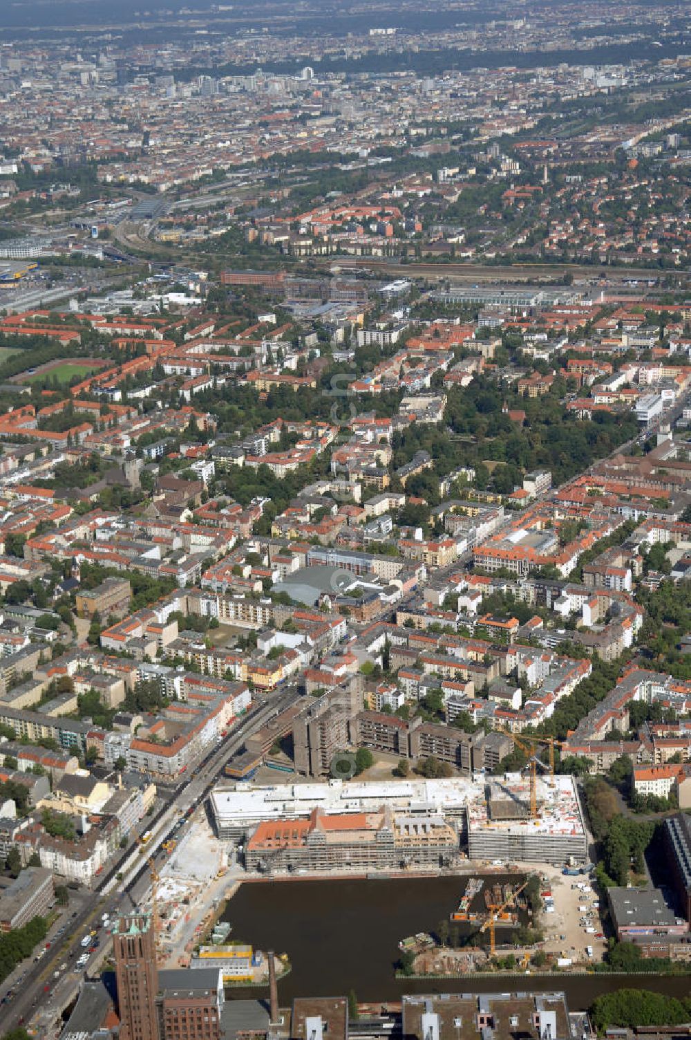 Berlin from the bird's eye view: Blick auf die Baustelle vom Umbau Hafen Tempelhof am Ullsteinhaus. Der Tempelhofer Hafen entstand 1906 zusammen mit dem Teltowkanal. Zwei Jahre später kam der Speicher hinzu, eine der ersten Stahlbetonbauten in Deutschland. Im Krieg wurde das Gebäude schwer zerstört. Nach dem Wiederaufbau lagerte dort ein Teil der Lebensmittel-Reserve für West-Berlin. Bis zum Herbst 2008 sollen neben einer Einzelhandelsfläche von knapp 20 000 Quadratmetern und eine Fläche von etwa 10000 Quadratmeter für Unterhaltung, Grünflächen und Flanierwege entstehen. Hierfür wird der alte Speicher von einem Neubau flankiert. Etwa 70 Geschäfte haben in beiden Gebäuden Platz. Auf dem Dach des Neubaus entstehen 600 Parkplätze. Der Hafen selbst bleibt exklusiv Fußgängern und Freizeitkapitänen vorbehalten. Adresse: Ordensmeisterstraße, 12099 Berlin-Tempelhof; Kontakt Architekt: REM+tec Architekten, Gesellschaft für Projektentwicklung und Denkmalschutz mbH, Kurfürstenstraße 132, 10785 Berlin,Tel. 030 264767-70, Fax 030 264767-47, info@remtec.eu,