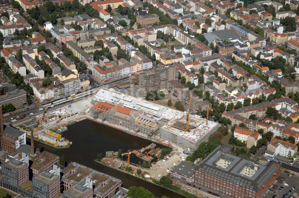 Aerial photograph Berlin - Blick auf die Baustelle vom Umbau Hafen Tempelhof am Ullsteinhaus. Der Tempelhofer Hafen entstand 1906 zusammen mit dem Teltowkanal. Zwei Jahre später kam der Speicher hinzu, eine der ersten Stahlbetonbauten in Deutschland. Im Krieg wurde das Gebäude schwer zerstört. Nach dem Wiederaufbau lagerte dort ein Teil der Lebensmittel-Reserve für West-Berlin. Bis zum Herbst 2008 sollen neben einer Einzelhandelsfläche von knapp 20 000 Quadratmetern und eine Fläche von etwa 10000 Quadratmeter für Unterhaltung, Grünflächen und Flanierwege entstehen. Hierfür wird der alte Speicher von einem Neubau flankiert. Etwa 70 Geschäfte haben in beiden Gebäuden Platz. Auf dem Dach des Neubaus entstehen 600 Parkplätze. Der Hafen selbst bleibt exklusiv Fußgängern und Freizeitkapitänen vorbehalten. Adresse: Ordensmeisterstraße, 12099 Berlin-Tempelhof; Kontakt Architekt: REM+tec Architekten, Gesellschaft für Projektentwicklung und Denkmalschutz mbH, Kurfürstenstraße 132, 10785 Berlin,Tel. 030 264767-70, Fax 030 264767-47, info@remtec.eu,