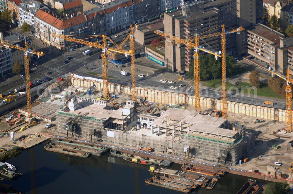 Aerial image Berlin - Blick auf die Baustelle vom Umbau Hafen Tempelhof am Ullsteinhaus. Der Tempelhofer Hafen entstand 1906 zusammen mit dem Teltowkanal. Zwei Jahre später kam der Speicher hinzu, eine der ersten Stahlbetonbauten in Deutschland. Im Krieg wurde das Gebäude schwer zerstört. Nach dem Wiederaufbau lagerte dort ein Teil der Lebensmittel-Reserve für West-Berlin. Bis zum Herbst 2008 sollen neben einer Einzelhandelsfläche von knapp 20 000 Quadratmetern und eine Fläche von etwa 10000 Quadratmeter für Unterhaltung, Grünflächen und Flanierwege entstehen. Hierfür wird der alte Speicher von einem Neubau flankiert. Etwa 70 Geschäfte haben in beiden Gebäuden Platz. Auf dem Dach des Neubaus entstehen 600 Parkplätze. Der Hafen selbst bleibt exklusiv Fußgängern und Freizeitkapitänen vorbehalten. Adresse: Ordensmeisterstraße, 12099 Berlin-Tempelhof; Kontakt Architekt: REM+tec Architekten, Gesellschaft für Projektentwicklung und Denkmalschutz mbH, Kurfürstenstraße 132, 10785 Berlin,Tel. 030 264767-70, Fax 030 264767-47, info@remtec.eu,