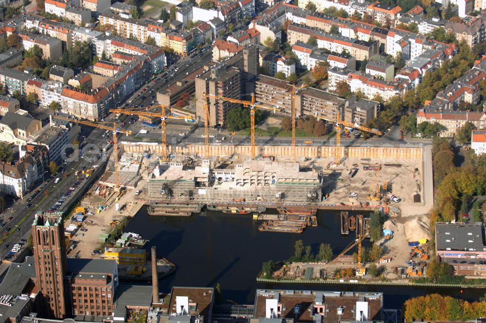 Aerial photograph Berlin - Blick auf die Baustelle vom Umbau Hafen Tempelhof am Ullsteinhaus. Der Tempelhofer Hafen entstand 1906 zusammen mit dem Teltowkanal. Zwei Jahre später kam der Speicher hinzu, eine der ersten Stahlbetonbauten in Deutschland. Im Krieg wurde das Gebäude schwer zerstört. Nach dem Wiederaufbau lagerte dort ein Teil der Lebensmittel-Reserve für West-Berlin. Bis zum Herbst 2008 sollen neben einer Einzelhandelsfläche von knapp 20 000 Quadratmetern und eine Fläche von etwa 10000 Quadratmeter für Unterhaltung, Grünflächen und Flanierwege entstehen. Hierfür wird der alte Speicher von einem Neubau flankiert. Etwa 70 Geschäfte haben in beiden Gebäuden Platz. Auf dem Dach des Neubaus entstehen 600 Parkplätze. Der Hafen selbst bleibt exklusiv Fußgängern und Freizeitkapitänen vorbehalten. Adresse: Ordensmeisterstraße, 12099 Berlin-Tempelhof; Kontakt Architekt: REM+tec Architekten, Gesellschaft für Projektentwicklung und Denkmalschutz mbH, Kurfürstenstraße 132, 10785 Berlin,Tel. 030 264767-70, Fax 030 264767-47, info@remtec.eu,