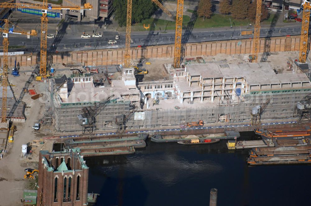 Berlin from above - Blick auf die Baustelle vom Umbau Hafen Tempelhof am Ullsteinhaus. Der Tempelhofer Hafen entstand 1906 zusammen mit dem Teltowkanal. Zwei Jahre später kam der Speicher hinzu, eine der ersten Stahlbetonbauten in Deutschland. Im Krieg wurde das Gebäude schwer zerstört. Nach dem Wiederaufbau lagerte dort ein Teil der Lebensmittel-Reserve für West-Berlin. Bis zum Herbst 2008 sollen neben einer Einzelhandelsfläche von knapp 20 000 Quadratmetern und eine Fläche von etwa 10000 Quadratmeter für Unterhaltung, Grünflächen und Flanierwege entstehen. Hierfür wird der alte Speicher von einem Neubau flankiert. Etwa 70 Geschäfte haben in beiden Gebäuden Platz. Auf dem Dach des Neubaus entstehen 600 Parkplätze. Der Hafen selbst bleibt exklusiv Fußgängern und Freizeitkapitänen vorbehalten. Adresse: Ordensmeisterstraße, 12099 Berlin-Tempelhof; Kontakt Architekt: REM+tec Architekten, Gesellschaft für Projektentwicklung und Denkmalschutz mbH, Kurfürstenstraße 132, 10785 Berlin,Tel. 030 264767-70, Fax 030 264767-47, info@remtec.eu,