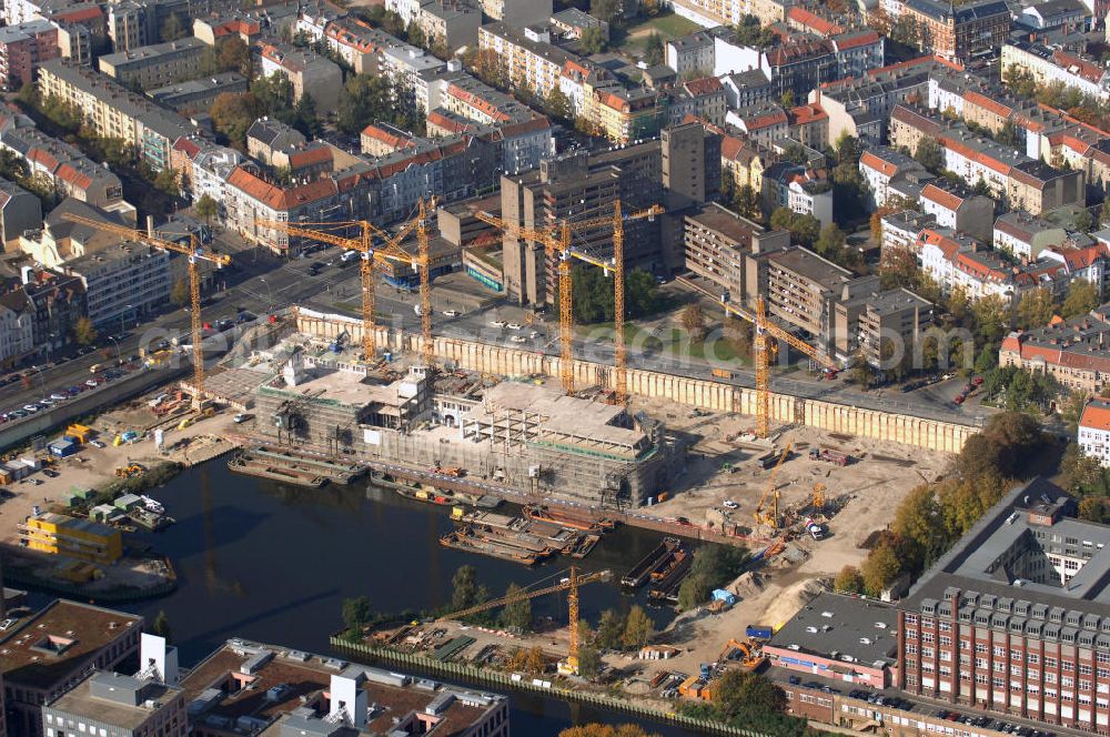 Aerial image Berlin - Blick auf die Baustelle vom Umbau Hafen Tempelhof am Ullsteinhaus. Der Tempelhofer Hafen entstand 1906 zusammen mit dem Teltowkanal. Zwei Jahre später kam der Speicher hinzu, eine der ersten Stahlbetonbauten in Deutschland. Im Krieg wurde das Gebäude schwer zerstört. Nach dem Wiederaufbau lagerte dort ein Teil der Lebensmittel-Reserve für West-Berlin. Bis zum Herbst 2008 sollen neben einer Einzelhandelsfläche von knapp 20 000 Quadratmetern und eine Fläche von etwa 10000 Quadratmeter für Unterhaltung, Grünflächen und Flanierwege entstehen. Hierfür wird der alte Speicher von einem Neubau flankiert. Etwa 70 Geschäfte haben in beiden Gebäuden Platz. Auf dem Dach des Neubaus entstehen 600 Parkplätze. Der Hafen selbst bleibt exklusiv Fußgängern und Freizeitkapitänen vorbehalten. Adresse: Ordensmeisterstraße, 12099 Berlin-Tempelhof; Kontakt Architekt: REM+tec Architekten, Gesellschaft für Projektentwicklung und Denkmalschutz mbH, Kurfürstenstraße 132, 10785 Berlin,Tel. 030 264767-70, Fax 030 264767-47, info@remtec.eu,