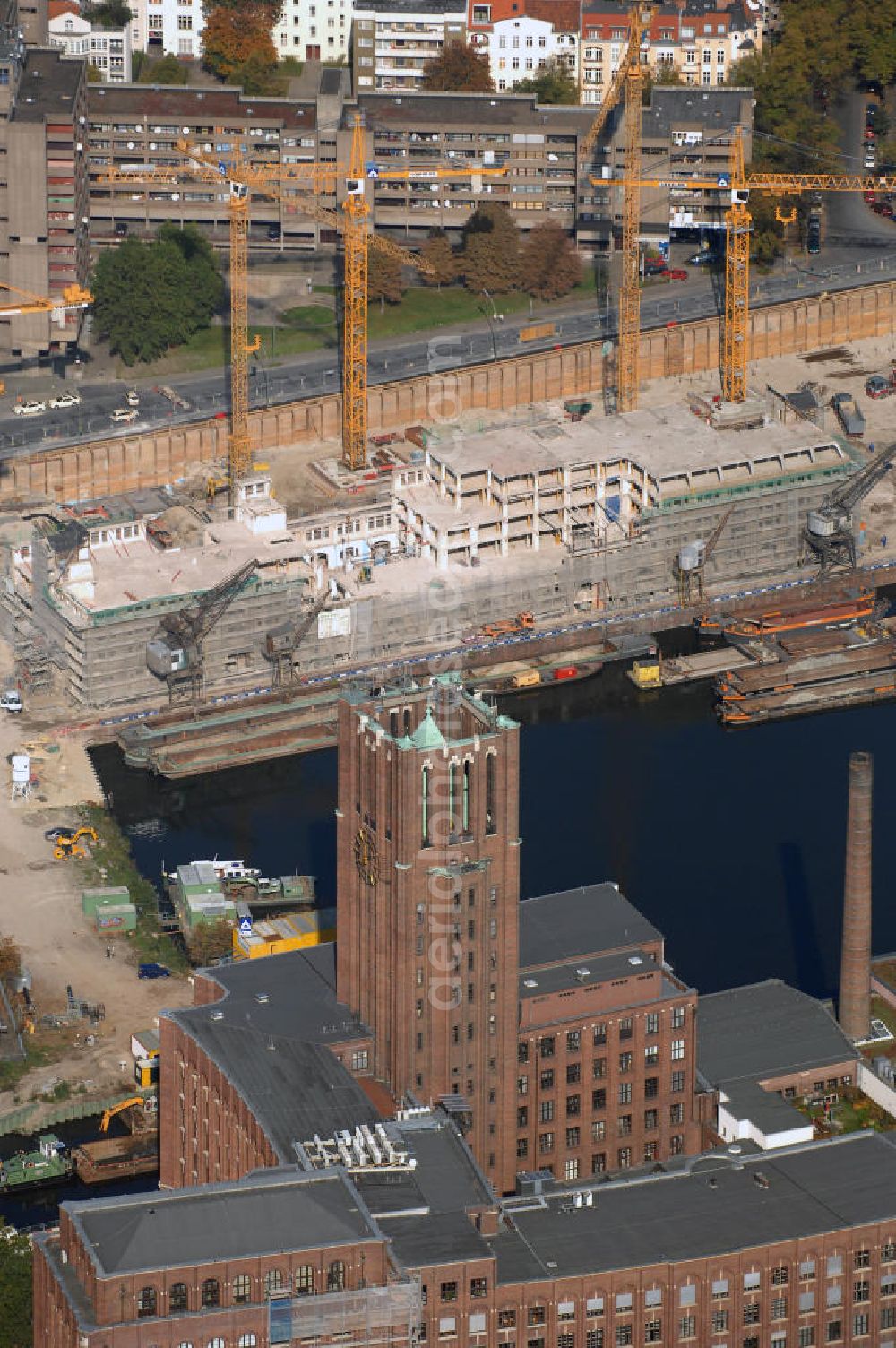 Berlin from the bird's eye view: Blick auf die Baustelle vom Umbau Hafen Tempelhof am Ullsteinhaus. Der Tempelhofer Hafen entstand 1906 zusammen mit dem Teltowkanal. Zwei Jahre später kam der Speicher hinzu, eine der ersten Stahlbetonbauten in Deutschland. Im Krieg wurde das Gebäude schwer zerstört. Nach dem Wiederaufbau lagerte dort ein Teil der Lebensmittel-Reserve für West-Berlin. Bis zum Herbst 2008 sollen neben einer Einzelhandelsfläche von knapp 20 000 Quadratmetern und eine Fläche von etwa 10000 Quadratmeter für Unterhaltung, Grünflächen und Flanierwege entstehen. Hierfür wird der alte Speicher von einem Neubau flankiert. Etwa 70 Geschäfte haben in beiden Gebäuden Platz. Auf dem Dach des Neubaus entstehen 600 Parkplätze. Der Hafen selbst bleibt exklusiv Fußgängern und Freizeitkapitänen vorbehalten. Adresse: Ordensmeisterstraße, 12099 Berlin-Tempelhof; Kontakt Architekt: REM+tec Architekten, Gesellschaft für Projektentwicklung und Denkmalschutz mbH, Kurfürstenstraße 132, 10785 Berlin,Tel. 030 264767-70, Fax 030 264767-47, info@remtec.eu,