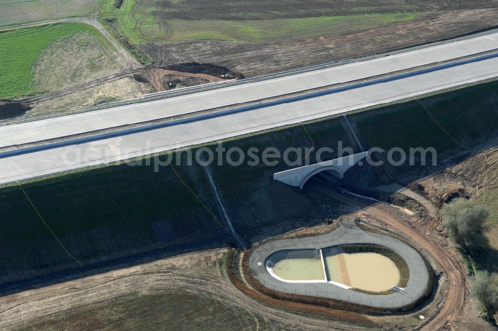 Aerial photograph Madelungen - Blick auf die Baustelle einer Unterführung der A4 mit Regenrückhaltebecken bei Madelungen. Der Neubau ist Teil des Projekt Nordverlegung / Umfahrung Hörselberge der Autobahn E40 / A4 in Thüringen bei Eisenach. Der Neubau ist Teil des Projekt Nordverlegung / Umfahrung Hörselberge der Autobahn E40 / A4 in Thüringen bei Eisenach. Durchgeführt werden die im Zuge dieses Projektes notwendigen Arbeiten unter an derem von den Mitarbeitern der Niederlassung Weimar der EUROVIA Verkehrsbau Union sowie der Niederlassungen Abbruch und Erdbau, Betonstraßenbau, Ingenieurbau und TECO Schallschutz der EUROVIA Beton sowie der DEGES.