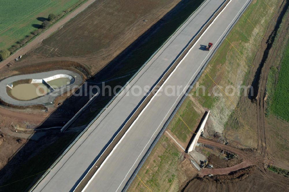 Aerial photograph Madelungen - Blick auf die Baustelle einer Unterführung der A4 mit Regenrückhaltebecken bei Madelungen. Der Neubau ist Teil des Projekt Nordverlegung / Umfahrung Hörselberge der Autobahn E40 / A4 in Thüringen bei Eisenach. Der Neubau ist Teil des Projekt Nordverlegung / Umfahrung Hörselberge der Autobahn E40 / A4 in Thüringen bei Eisenach. Durchgeführt werden die im Zuge dieses Projektes notwendigen Arbeiten unter an derem von den Mitarbeitern der Niederlassung Weimar der EUROVIA Verkehrsbau Union sowie der Niederlassungen Abbruch und Erdbau, Betonstraßenbau, Ingenieurbau und TECO Schallschutz der EUROVIA Beton sowie der DEGES.