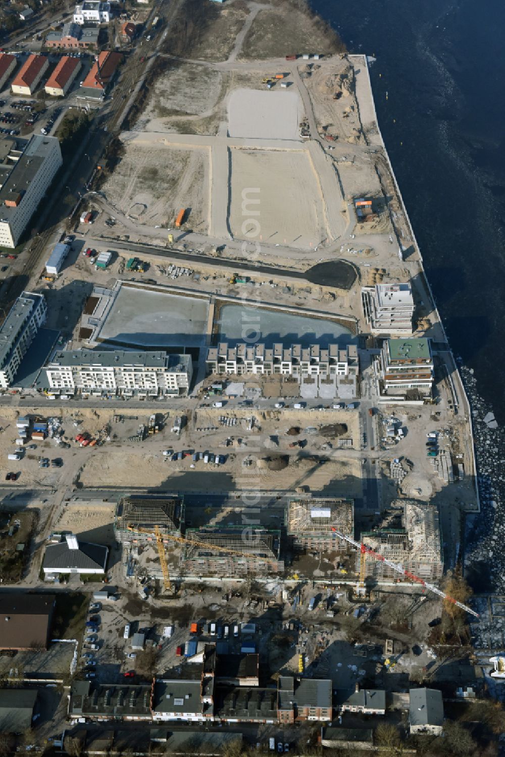 Berlin from the bird's eye view: Residential area construction site with multi-family housing development - new building Neue Wasserliebe - 52 Grad Nord Wohnen am Wasser in Berlin-Gruenau on the banks of the river Dahme at Teichmummelring - An der Dahme - Gaffelsteig - Regattastrasse in the district of Gruenau in Berlin, Germany