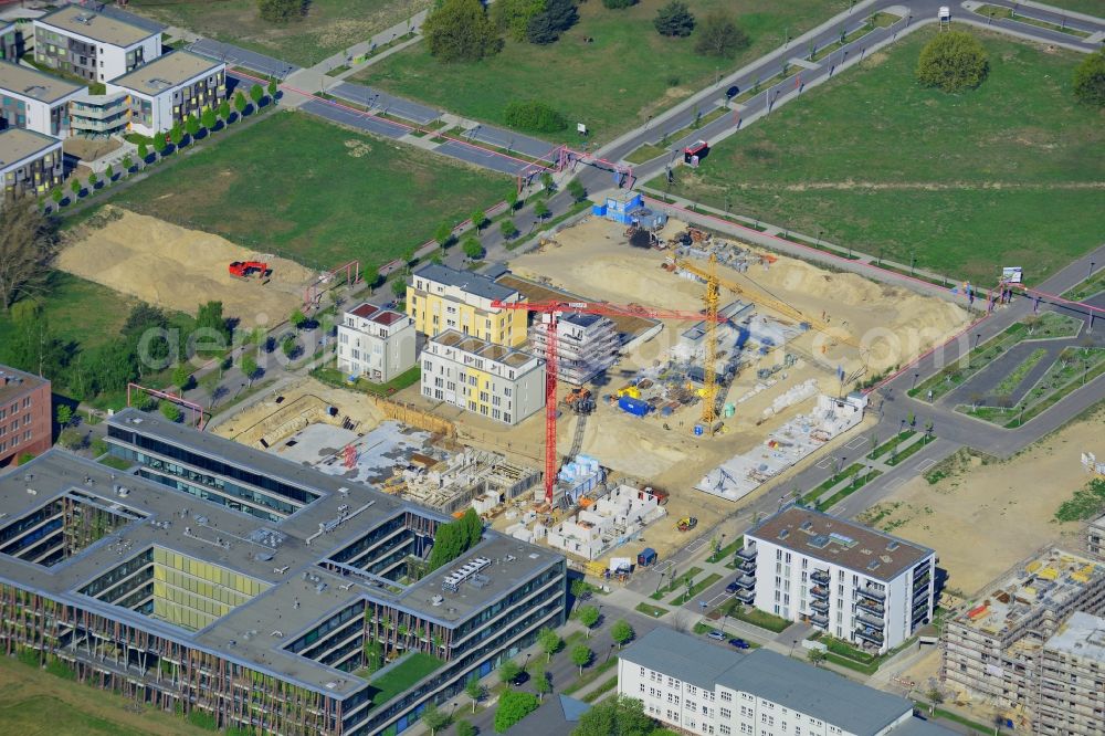 Aerial photograph Berlin - Construction site of the residential area Isaac Newton Park in the technology park of Adlershof in the Treptow-Koepenick district of Berlin in Germany. Adlershof consists of the technology park and industrial area and wide green areas and residential estates. Elaborate architecture is characteristic for the economy location and is currently created on Newtonstrasse. Single family, multi-family and semi-detached houses are being built on site