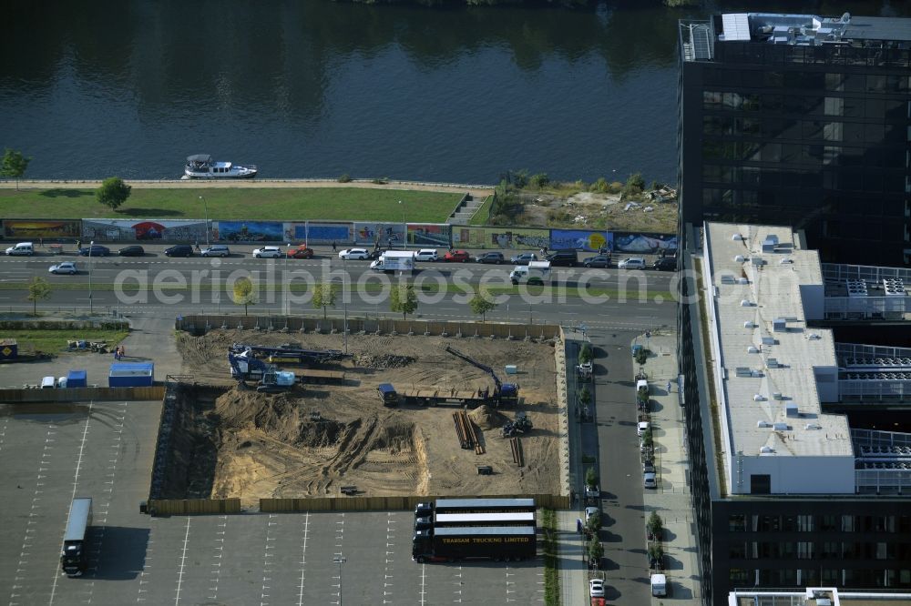 Aerial image Berlin - Construction site for the new building of an office building in the Anschutz Area - Mediaspree on the riverbank of the river Spree in Berlin in Germany. The building belongs to Bischoff & Compagnons