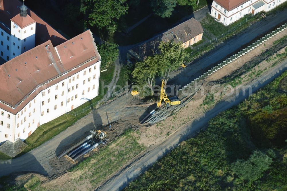 Pretzsch (Elbe) from the bird's eye view: Construction site of a new levee at the castle park and palace of Pretzsch (Elbe) in the state of Saxony-Anhalt. The levee is being put in place for protection against flooding and high tide of the river Elbe