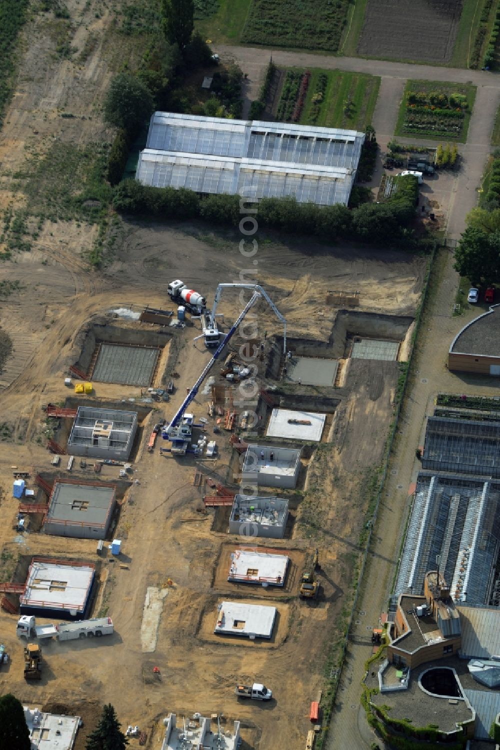 Aerial photograph Berlin - Construction site of a single family and semi-detached house settlement on Mohriner Allee of the Britz part of Berlin in Germany. The compound will include single family houses and residential buildings of different sizes. The compound is located next to the architectural distinct Pflanzenschutzamt (plant protection office of Berlin)