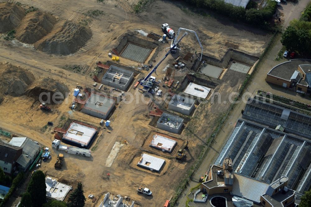 Berlin from above - Construction site of a single family and semi-detached house settlement on Mohriner Allee of the Britz part of Berlin in Germany. The compound will include single family houses and residential buildings of different sizes. The compound is located next to the architectural distinct Pflanzenschutzamt (plant protection office of Berlin)