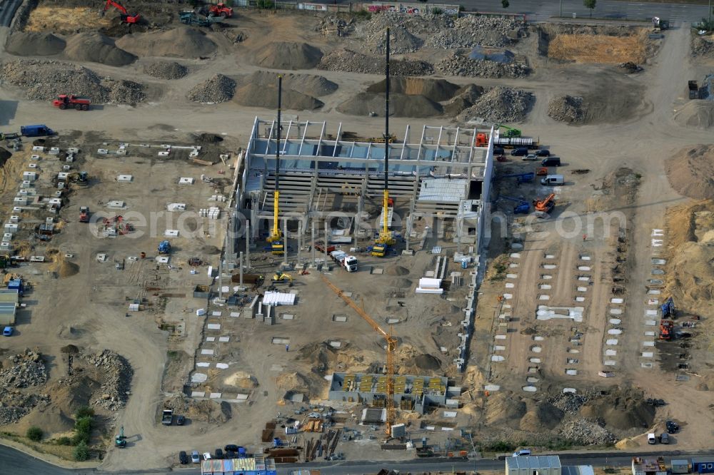 Berlin from the bird's eye view: Construction site for the new building of a commercial area with stores on Schnellerstrasse in the Niederschoeneweide part of the district of Treptow-Koepenick in Berlin in Germany. The area is being developed on the Spree riverbank in the renovation and redevelopement area of Treptow-Niederschoeneweide